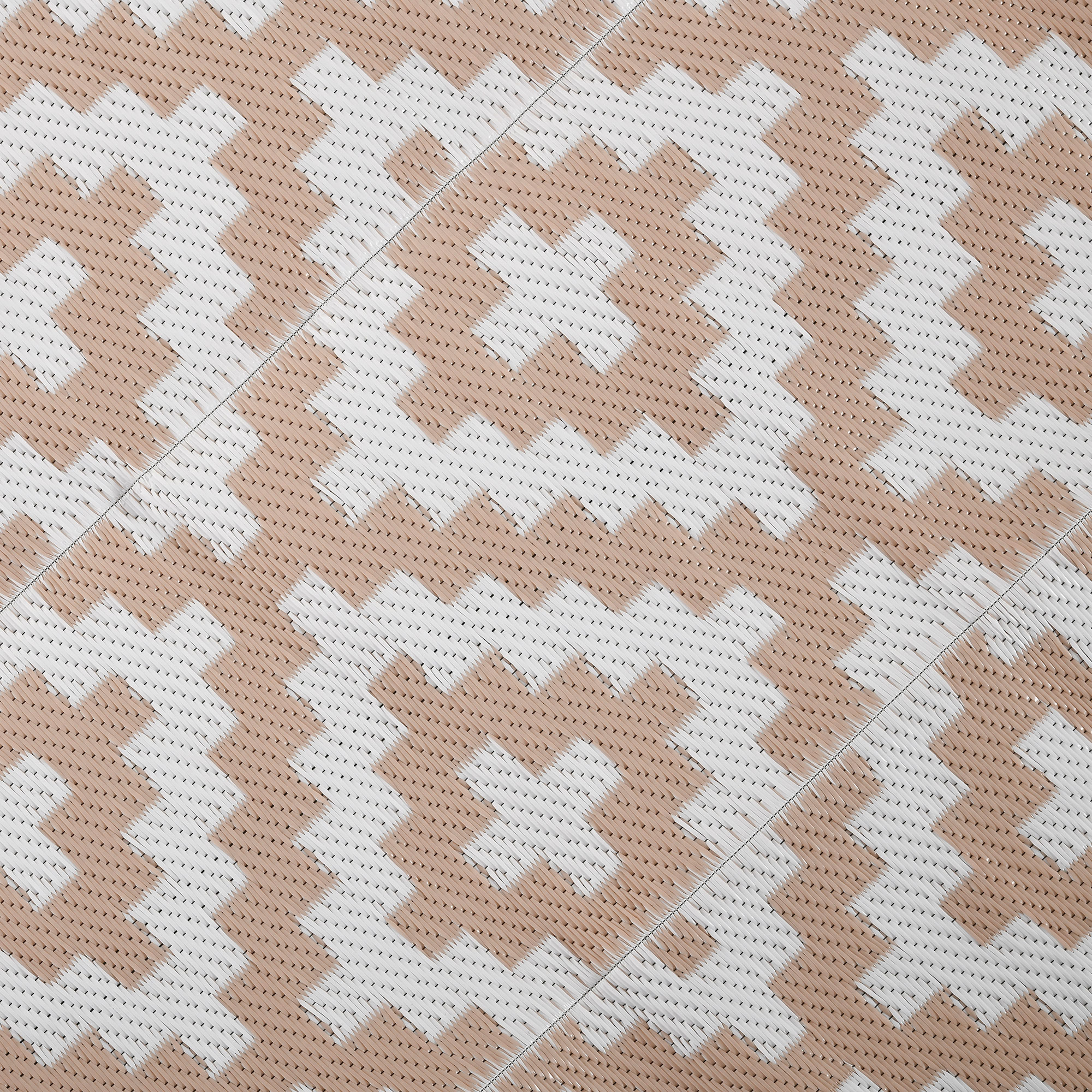 Un patrón de líneas en zigzag beige y blancas sobre una alfombra.