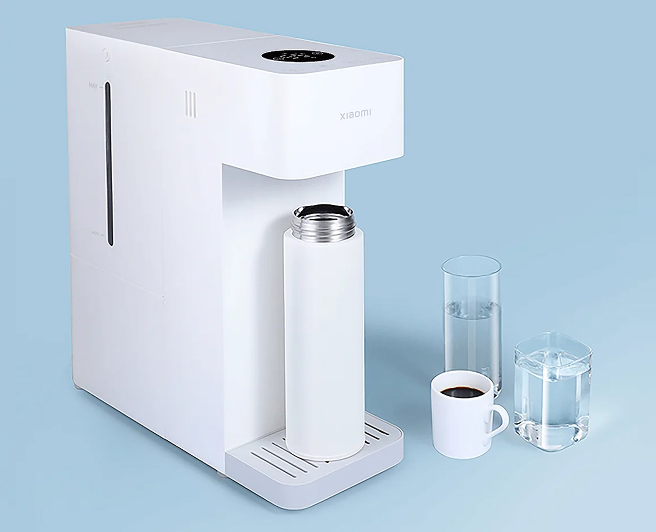 Ein weißer Wasserdispenser mit Flasche, Tasse und Gläsern auf blauem Hintergrund.