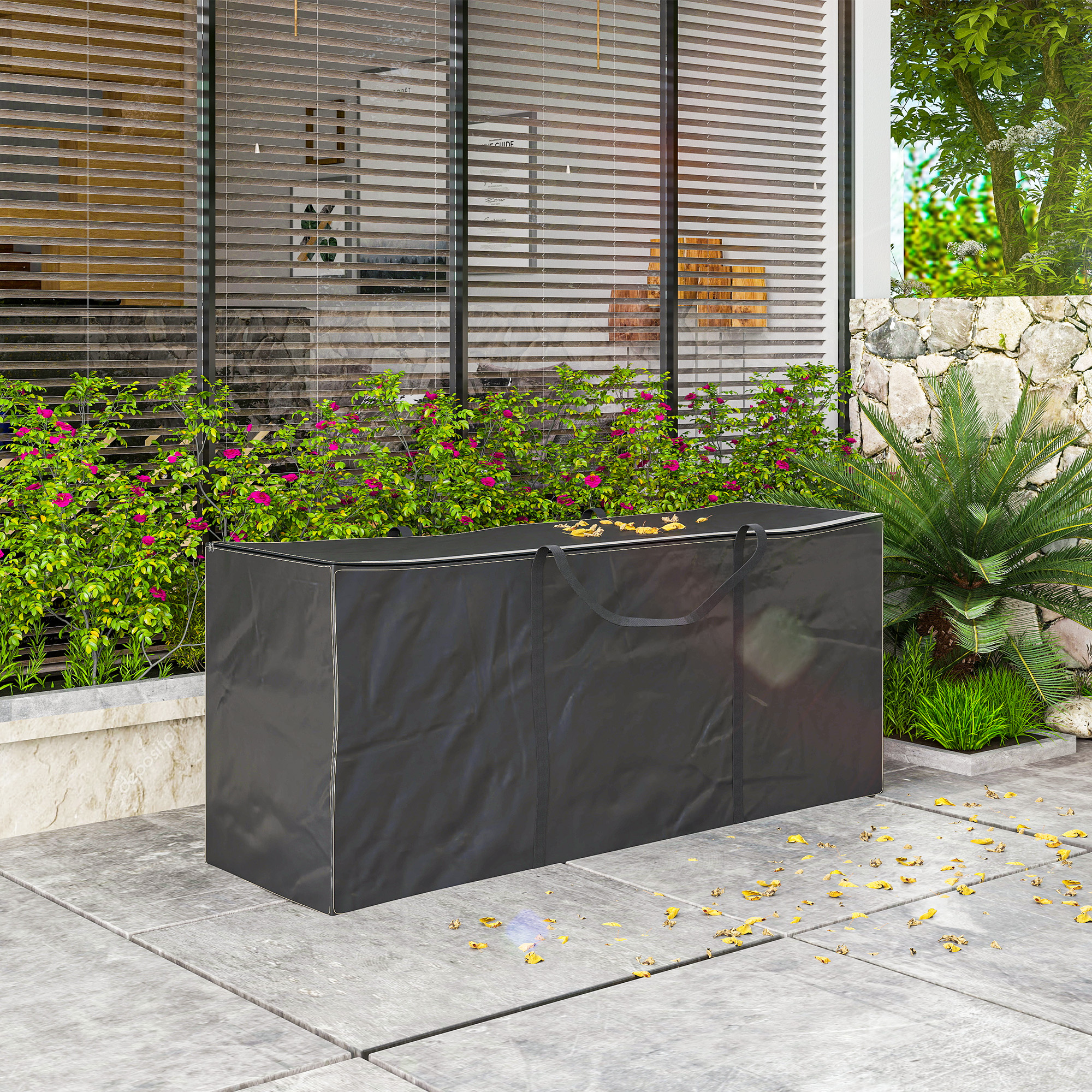 Una bolsa de almacenamiento negra se encuentra en un patio pavimentado junto a plantas verdes.
