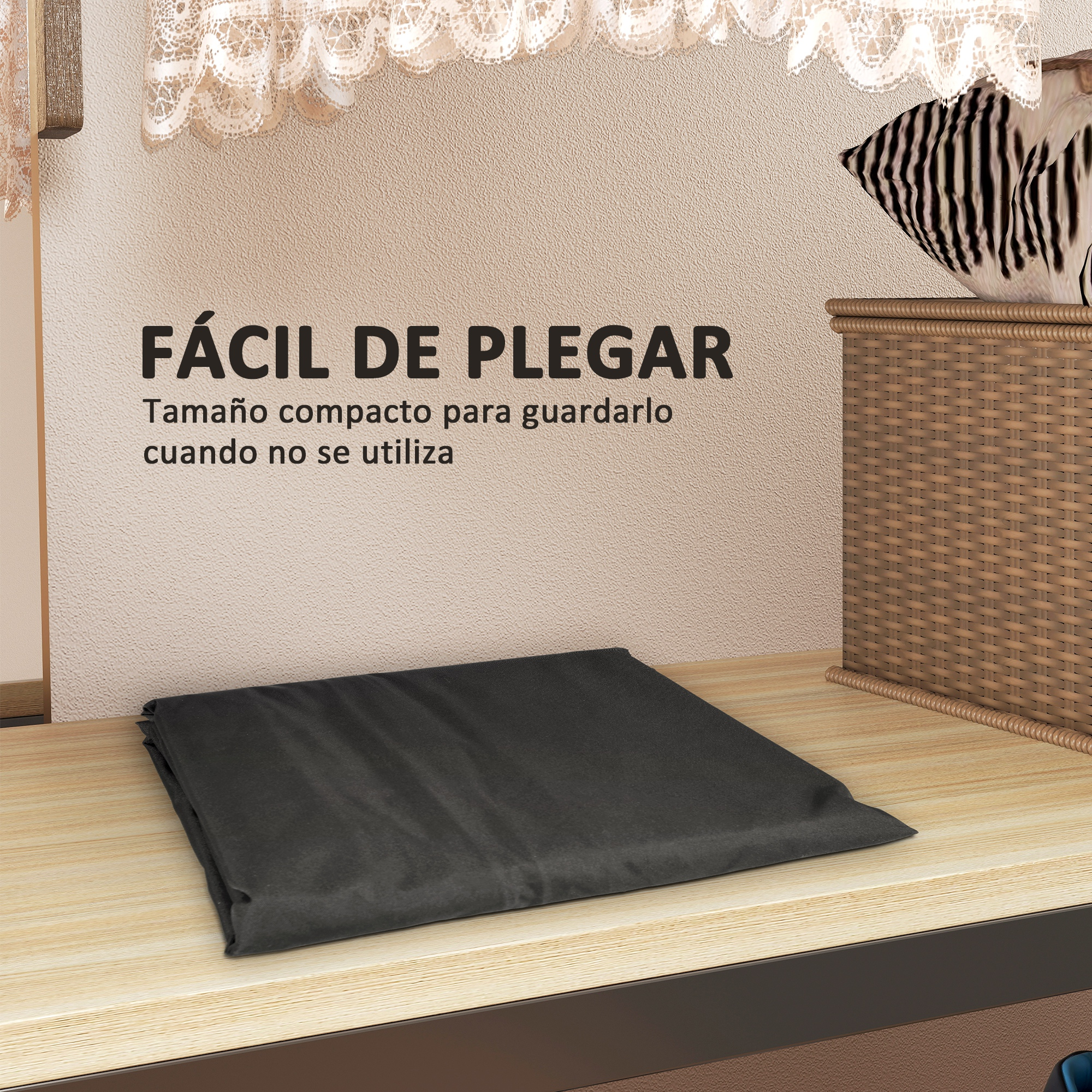 Una tela negra doblada sobre una mesa de madera. Al lado, una cesta de mimbre.