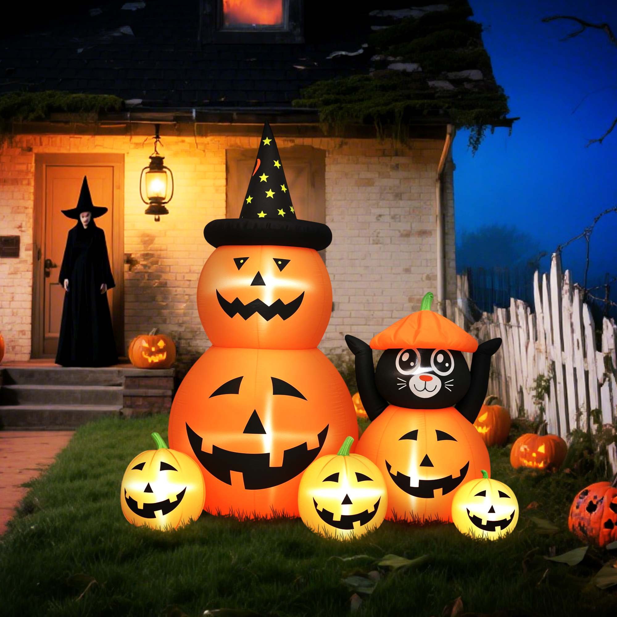 Decoración inflable de Halloween con calabazas, gato negro y bruja fuera de una casa.
