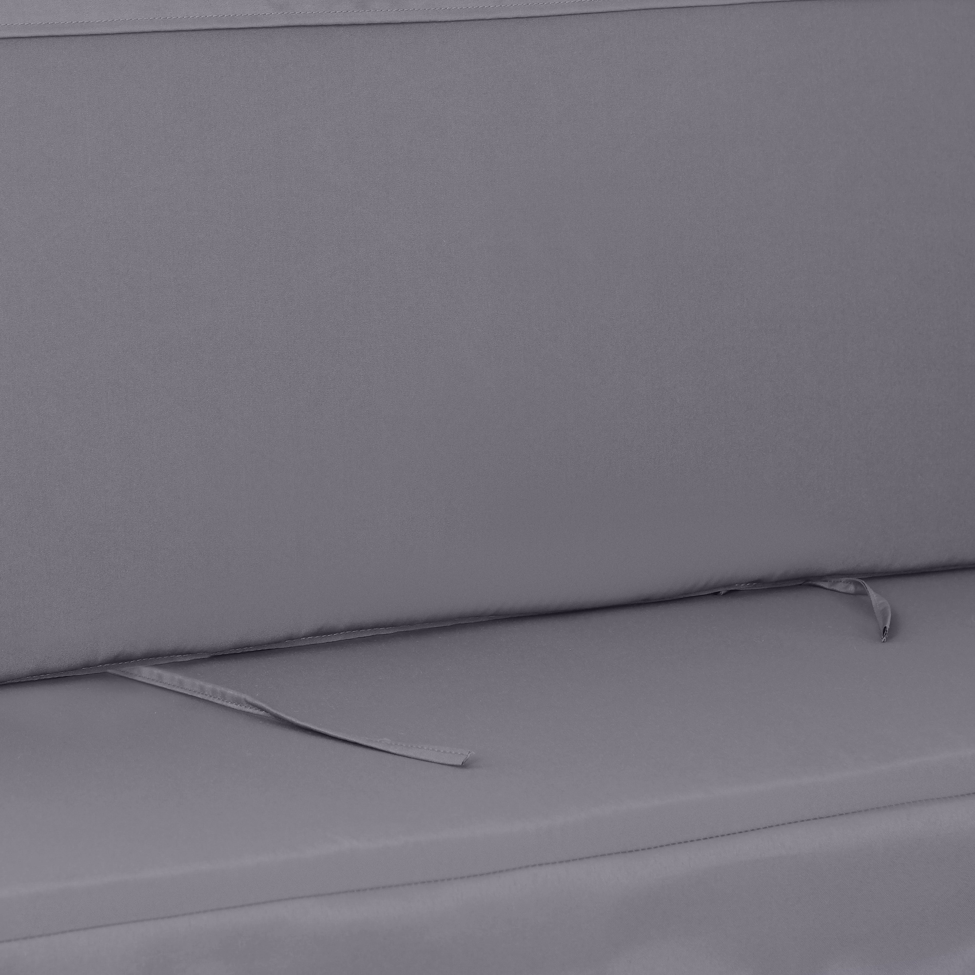 Cuscino in tessuto grigio con cuciture e legacci.