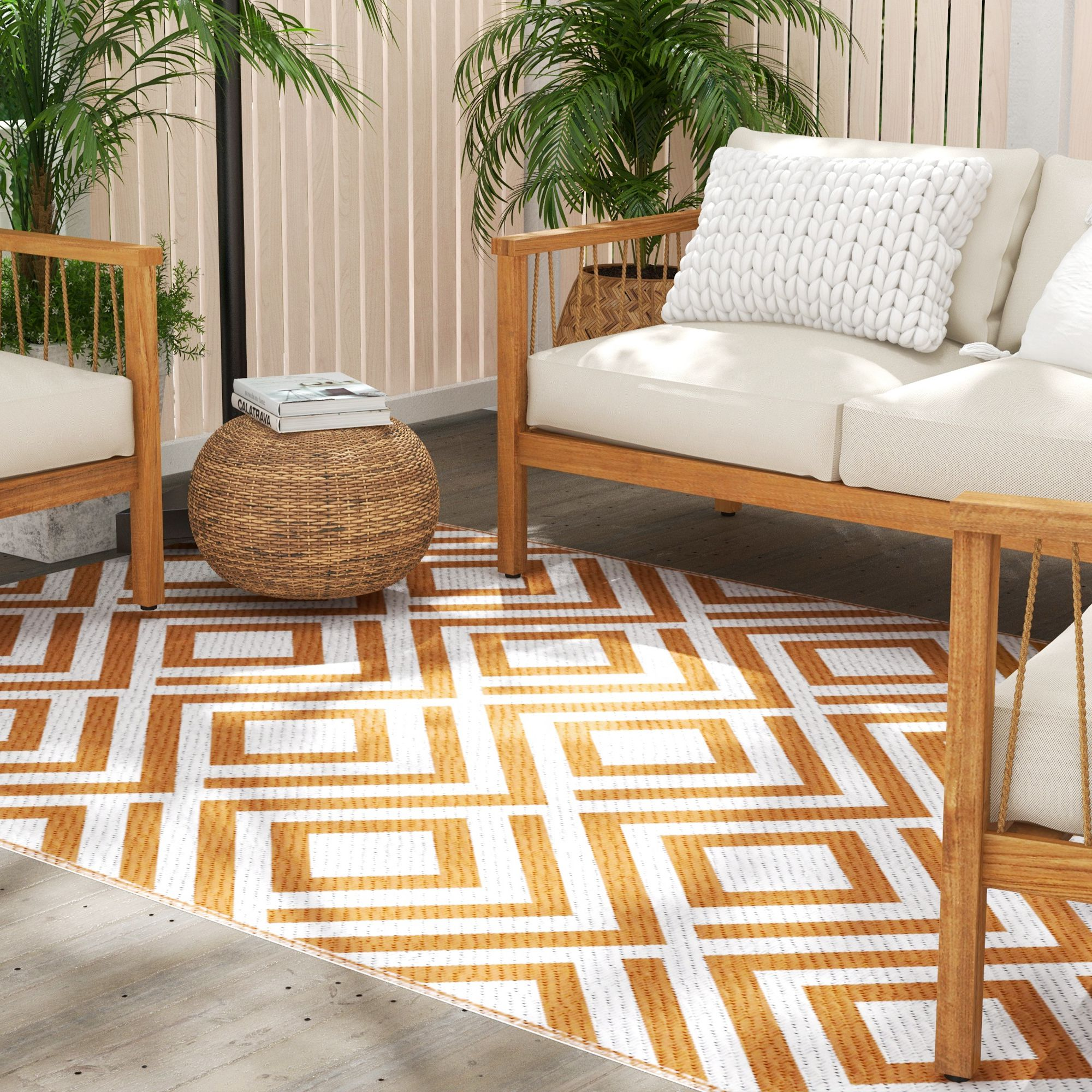 Muebles de madera con cojines blancos y alfombra geométrica naranja y blanca.