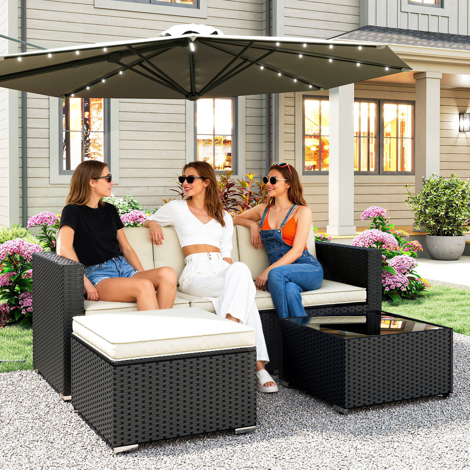 Tres mujeres sentadas en un sofá bajo un parasol con luces. Una casa al fondo.