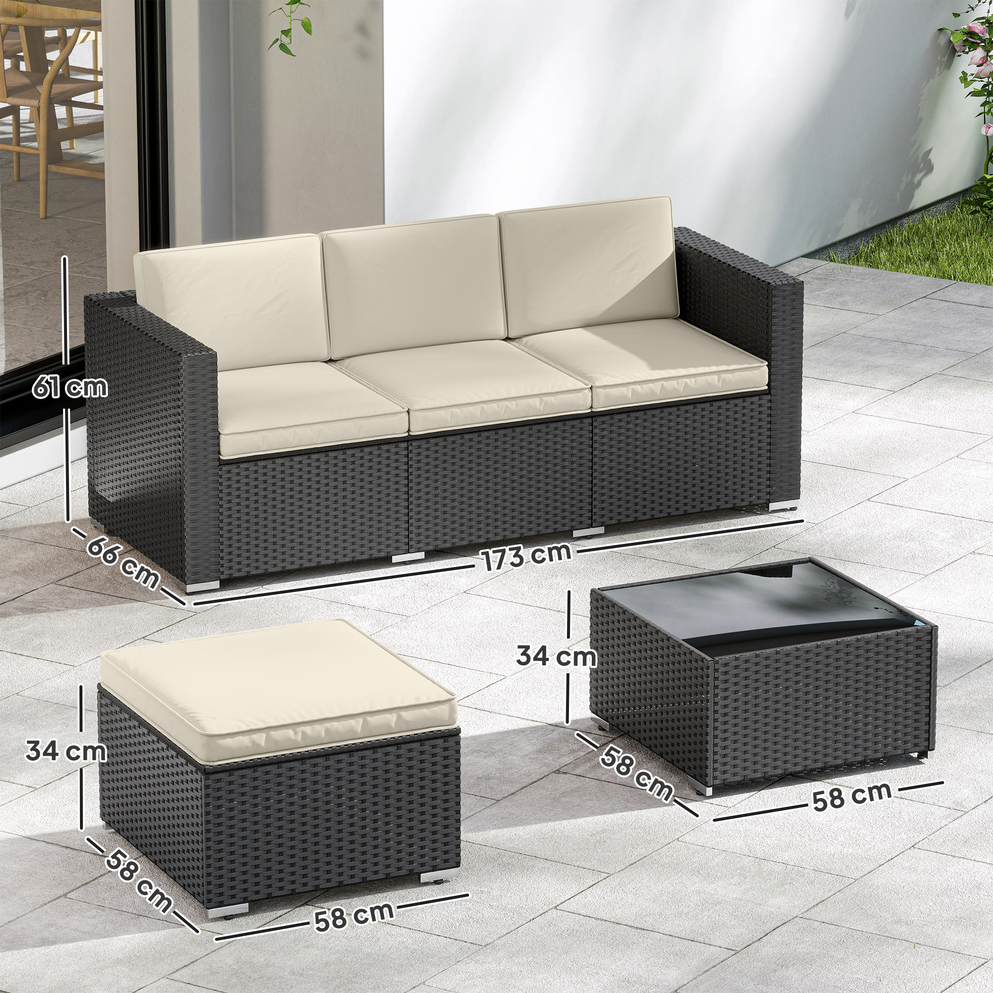 Sofá de ratán gris oscuro con cojines beige, otomana y mesa en un patio.