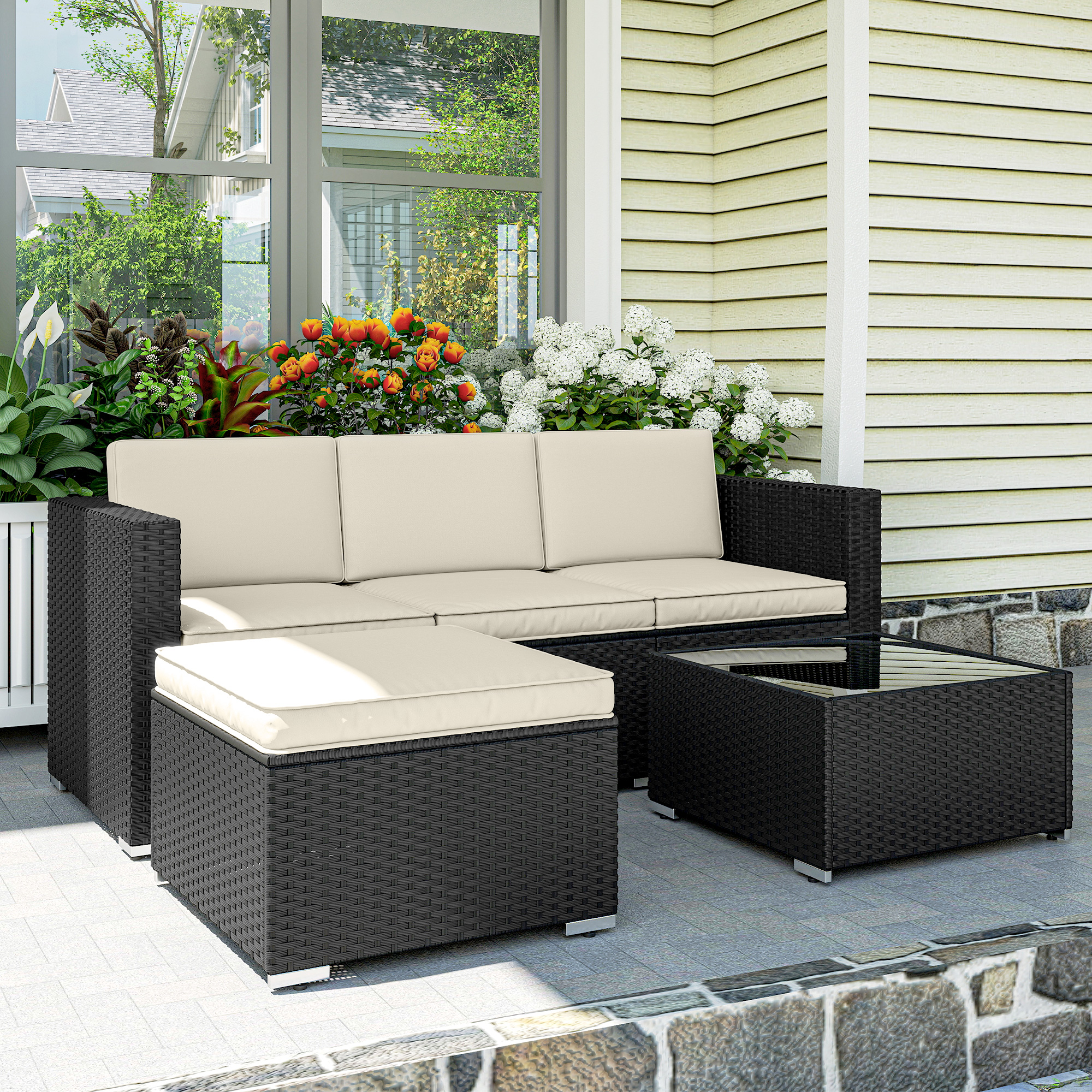 Juego de patio de mimbre negro con cojines beige, mesa de centro de cristal, en patio.