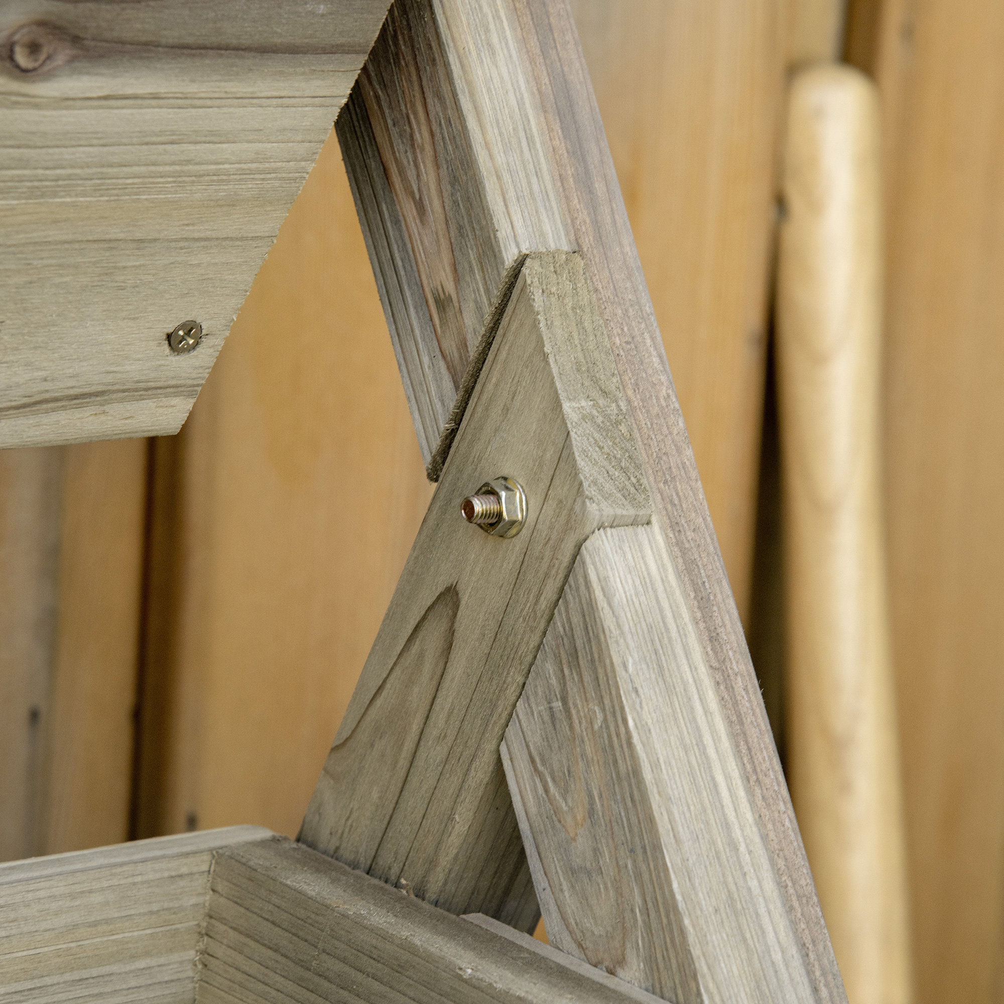 Primer plano de estructuras de madera con tornillos y un perno.