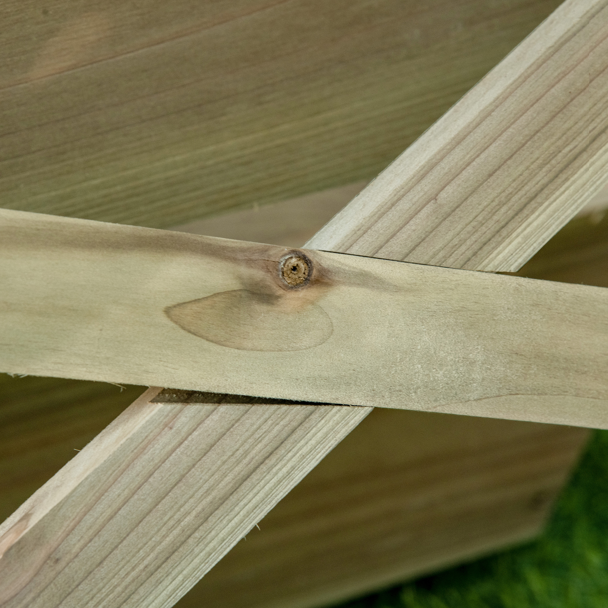 Vigas de madera con nudo sobre césped verde.