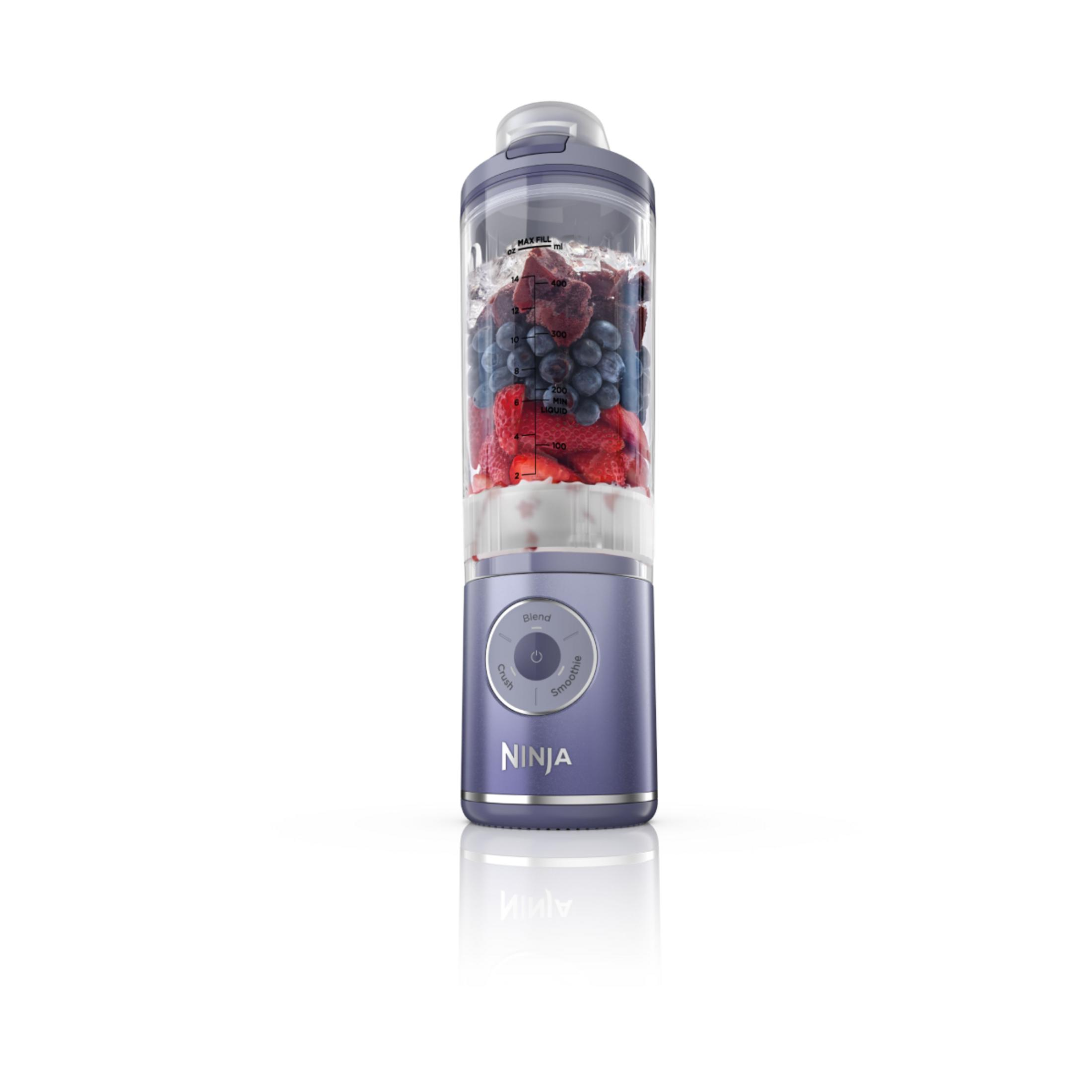 Frullatore Ninja viola riempito di frutta e cubetti di ghiaccio.