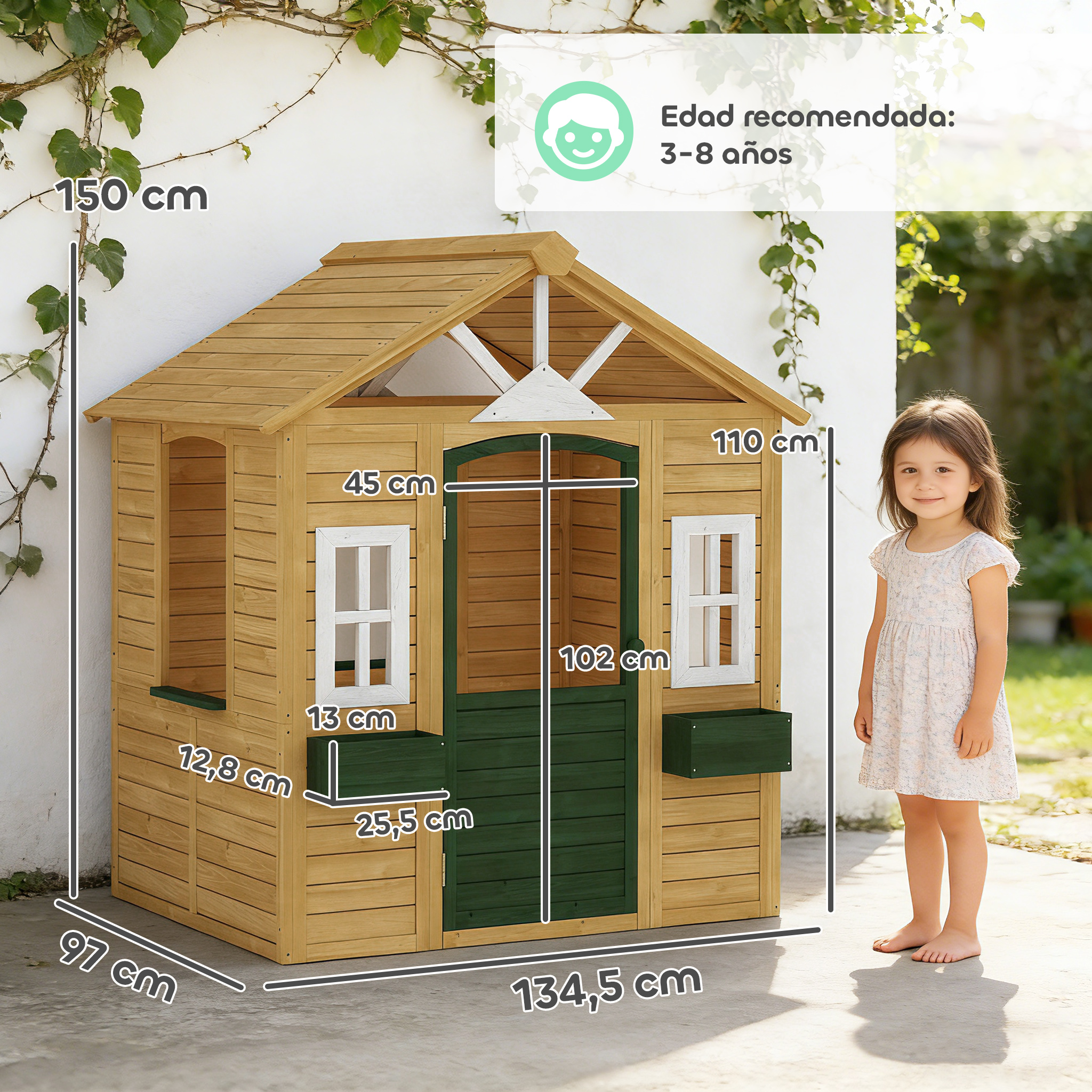 Casa de juegos de madera con ventanas, puerta y jardineras. Un niño al lado.