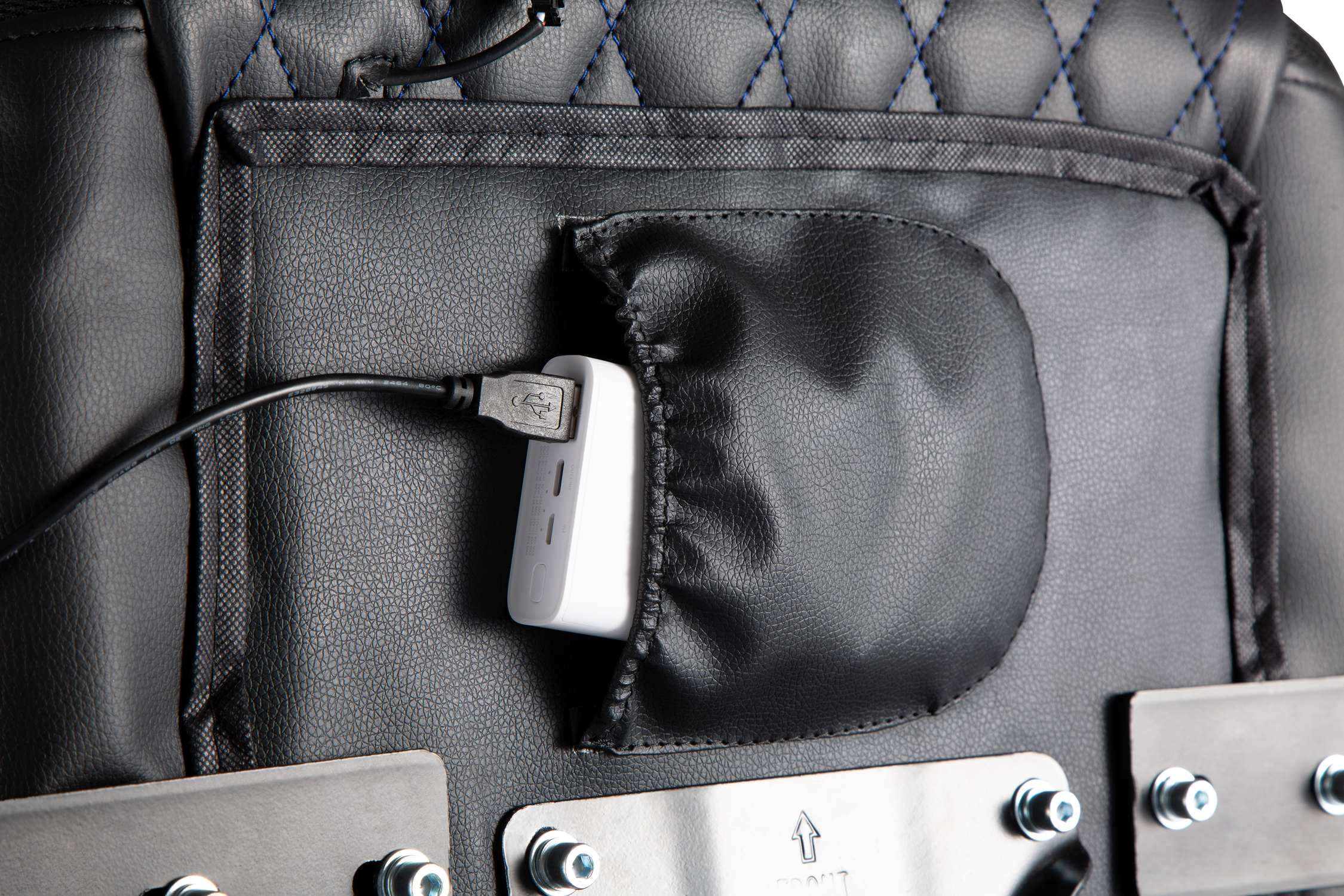 Ein weißer USB-Adapter steckt in einer schwarzen Tasche auf einer schwarzen Lederfläche.