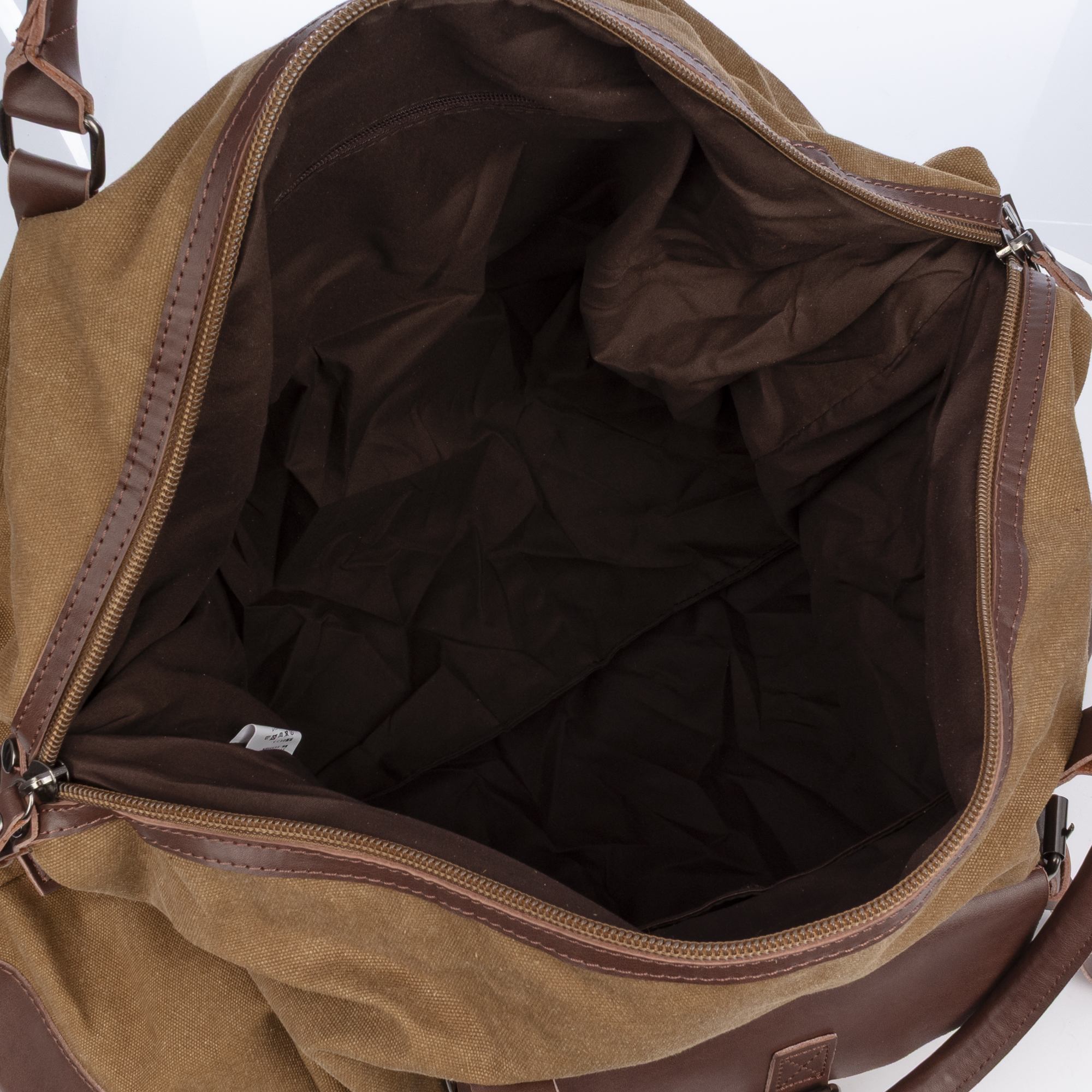 Un bolso de lona marrón con detalles de cuero marrón, abierto con interior vacío.