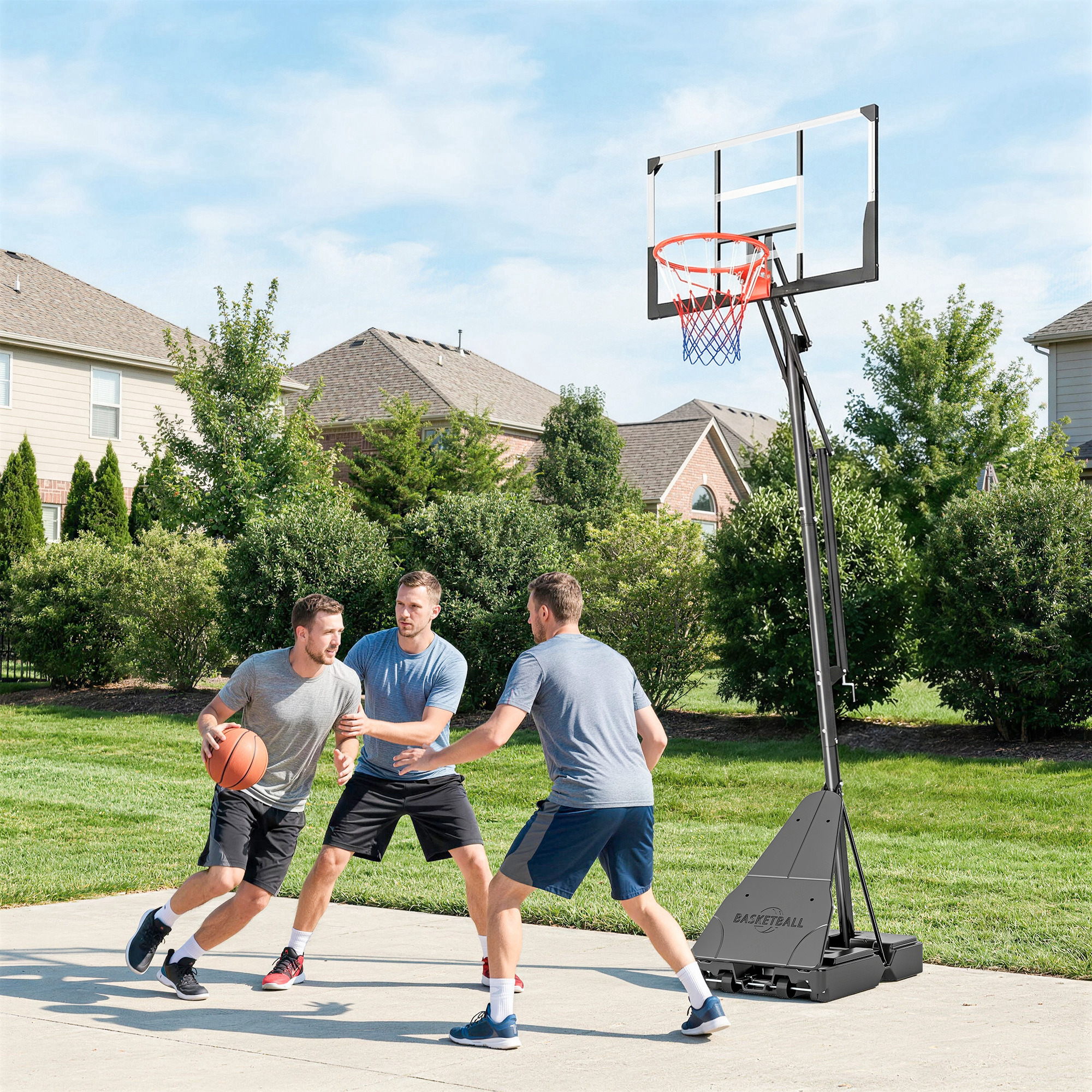 Tres hombres juegan al baloncesto en una entrada con una canasta portátil.