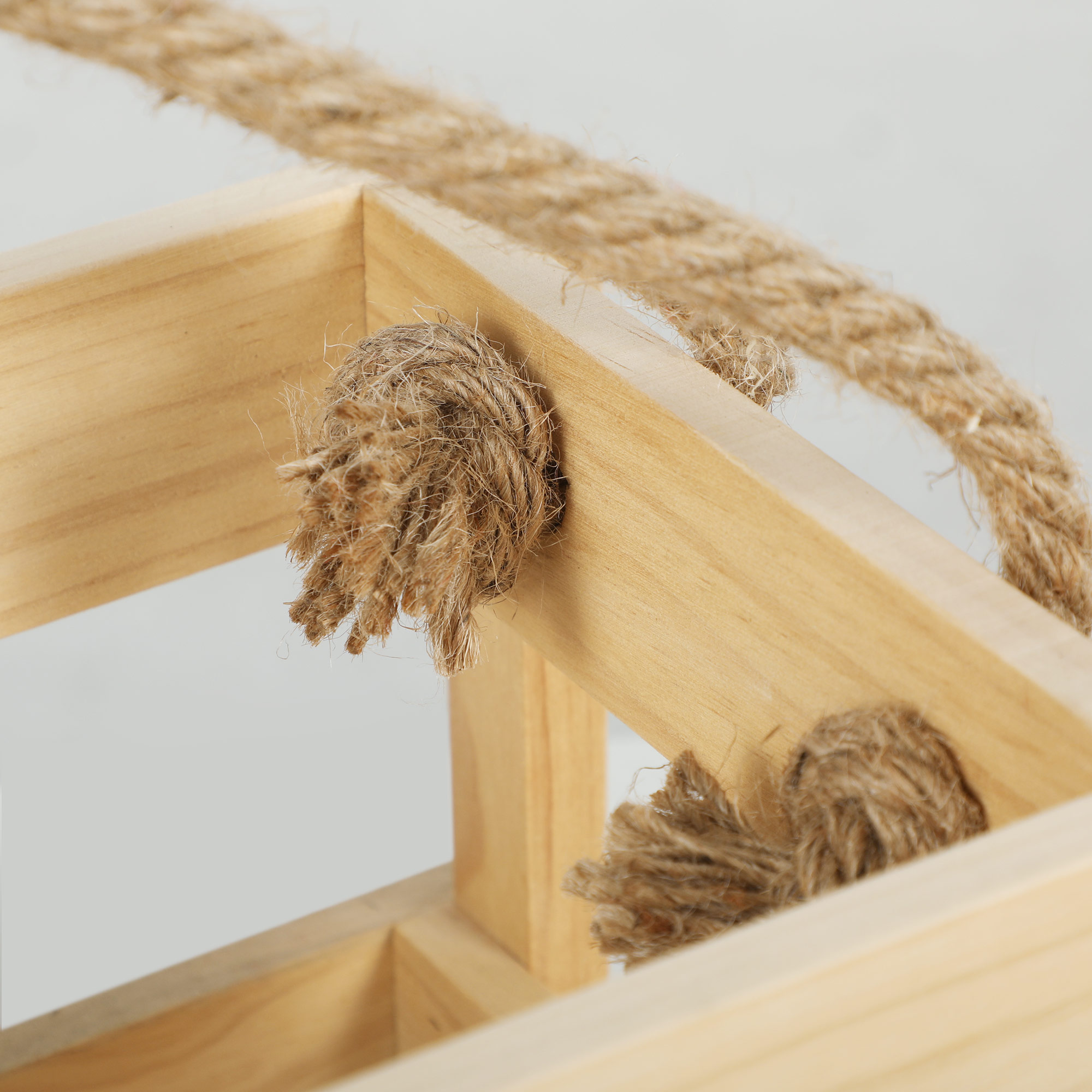 Caja de madera con asas de cuerda, vista de cerca.