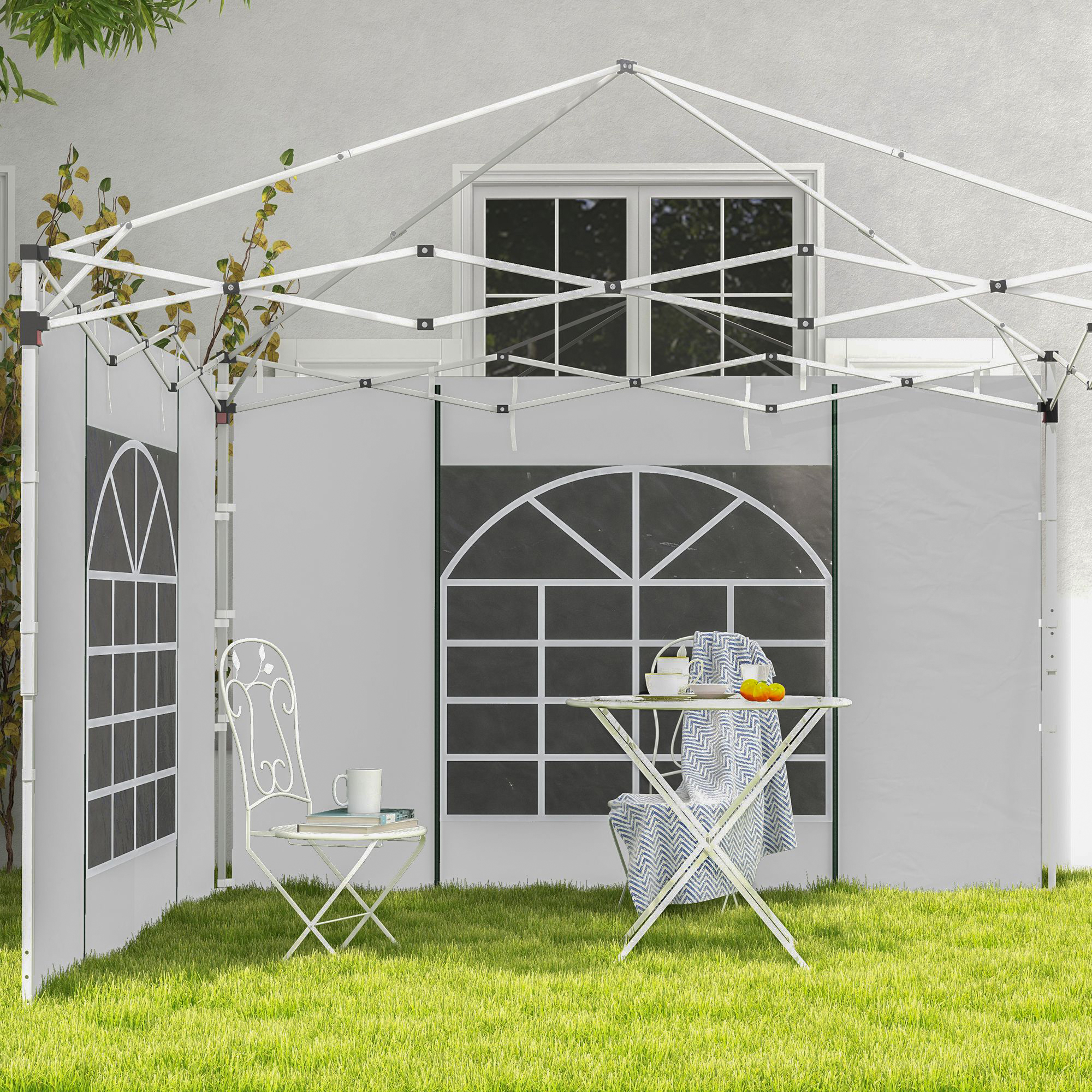 Un toldo blanco con paredes laterales, mesa y silla sobre césped verde.