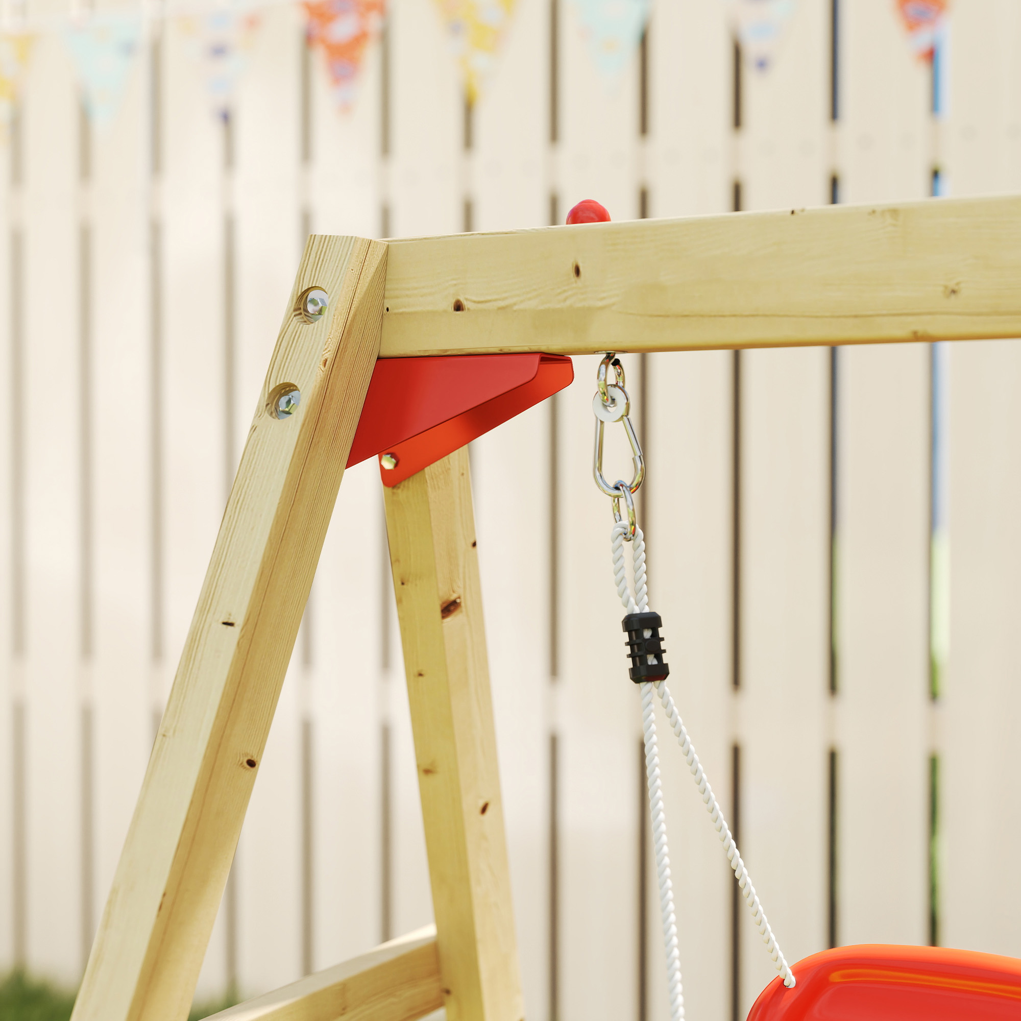 Estructura de columpio de madera con asiento rojo, herrajes metálicos y banderines.