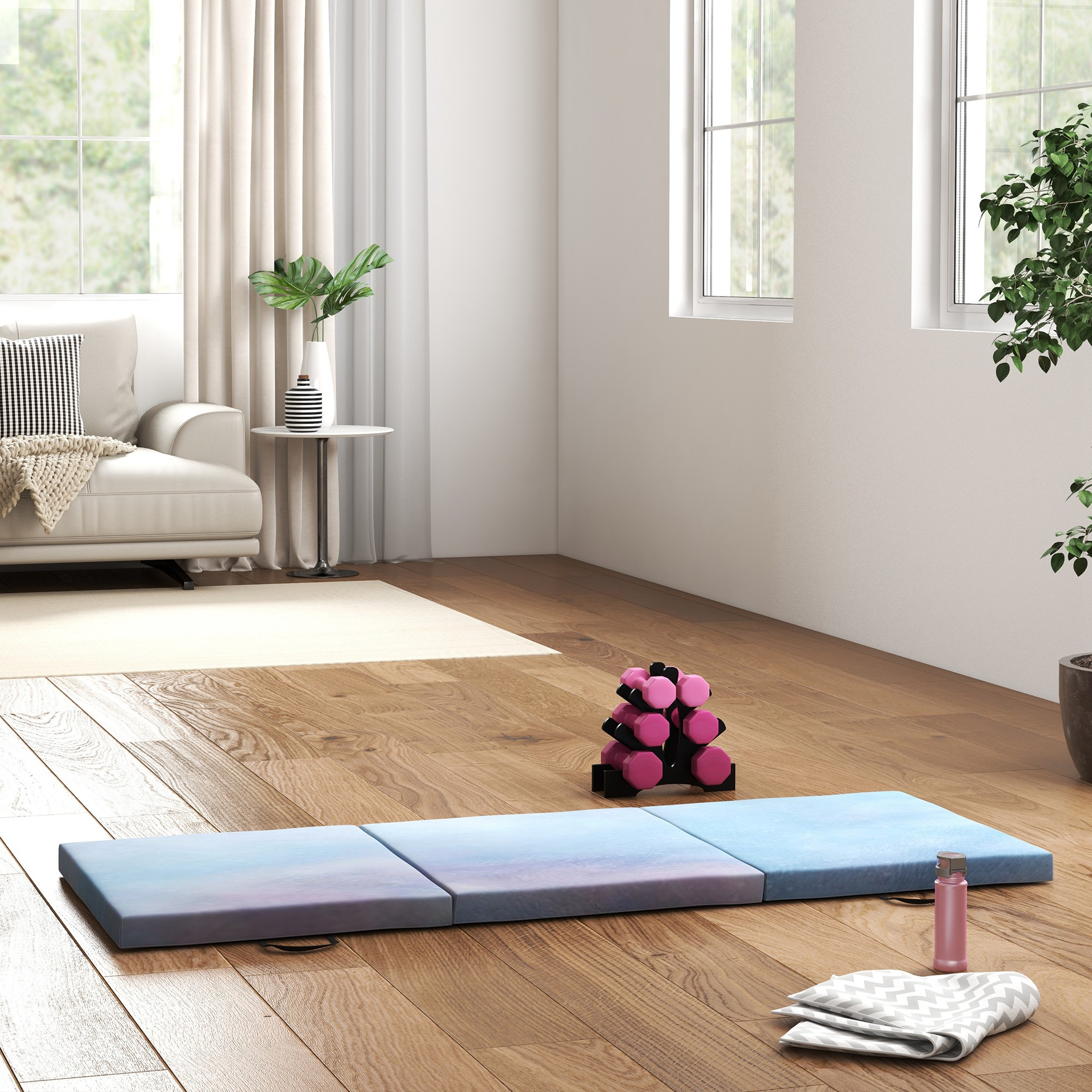 Una esterilla de yoga azul degradada yace sobre un suelo de madera. Hay pesas y una toalla cerca.
