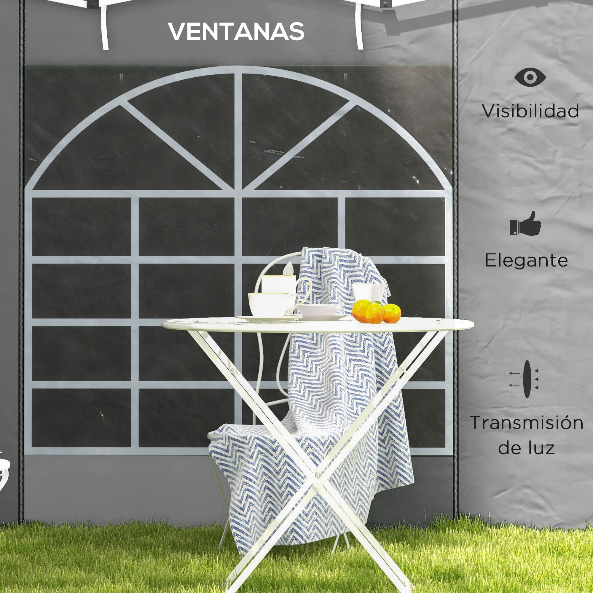 Una mesa blanca con paño azul, tazas y naranjas sobre césped frente a una ventana.