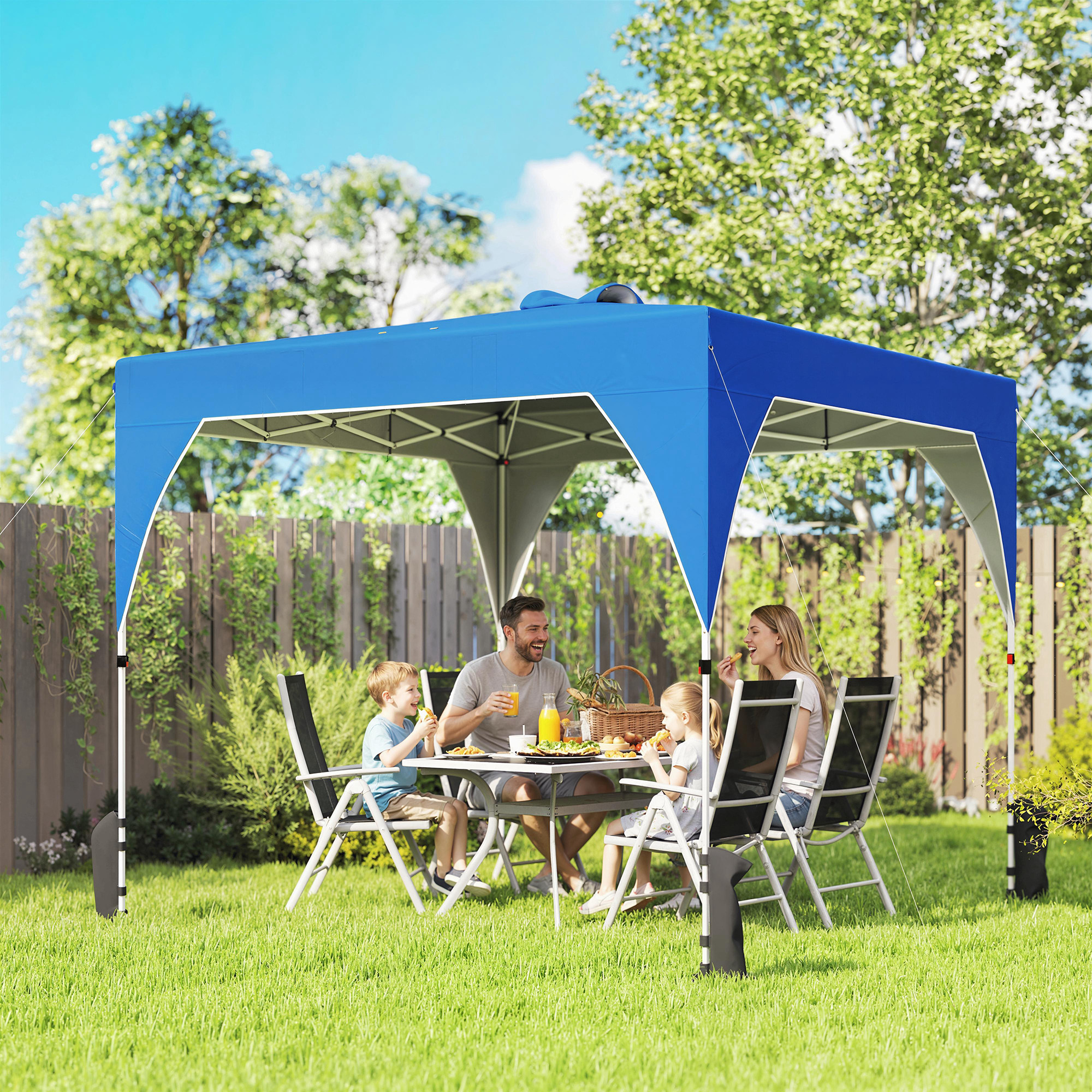 Familia disfruta picnic bajo toldo azul en patio trasero.