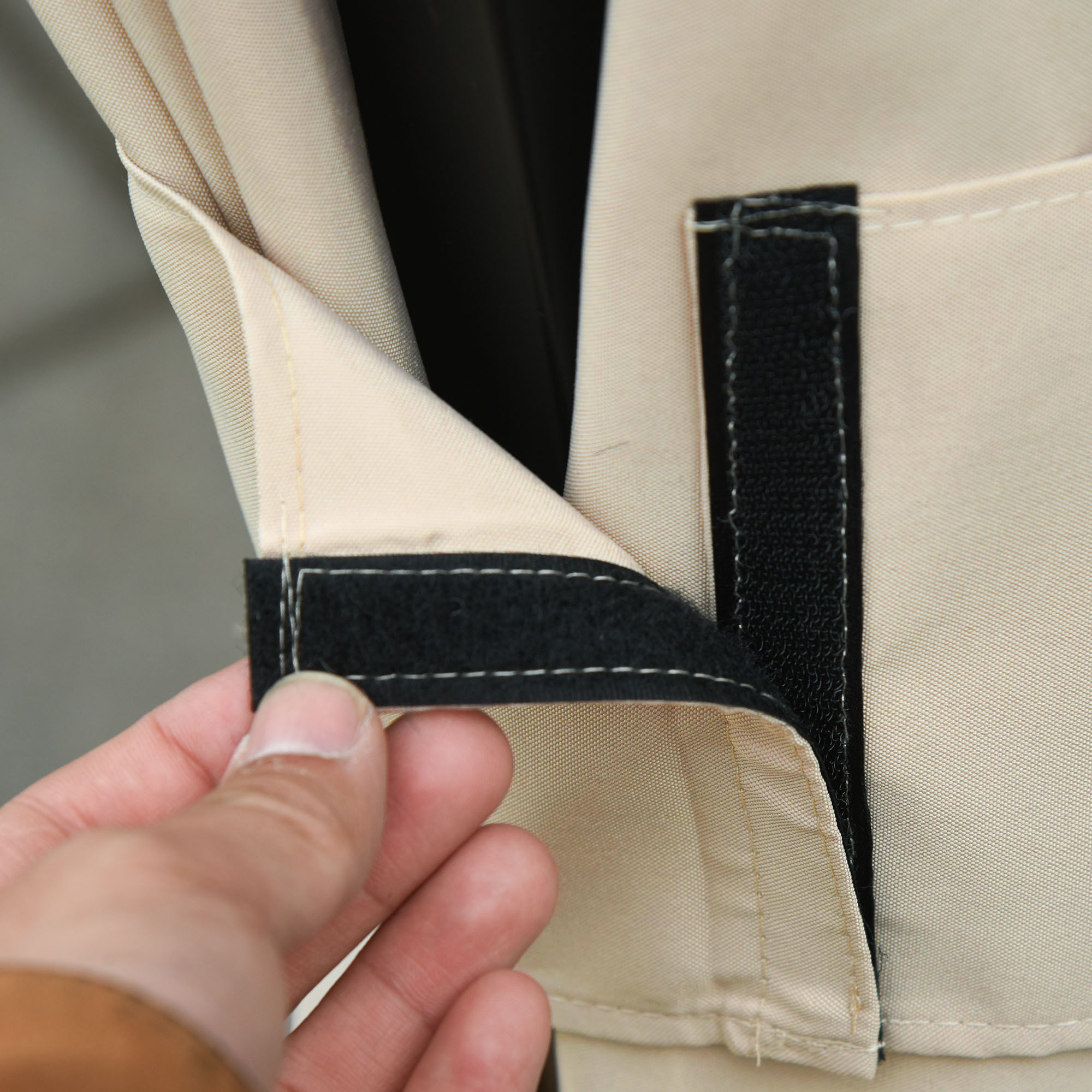 Una mano abrocha velcro en una cubierta de tela color canela.