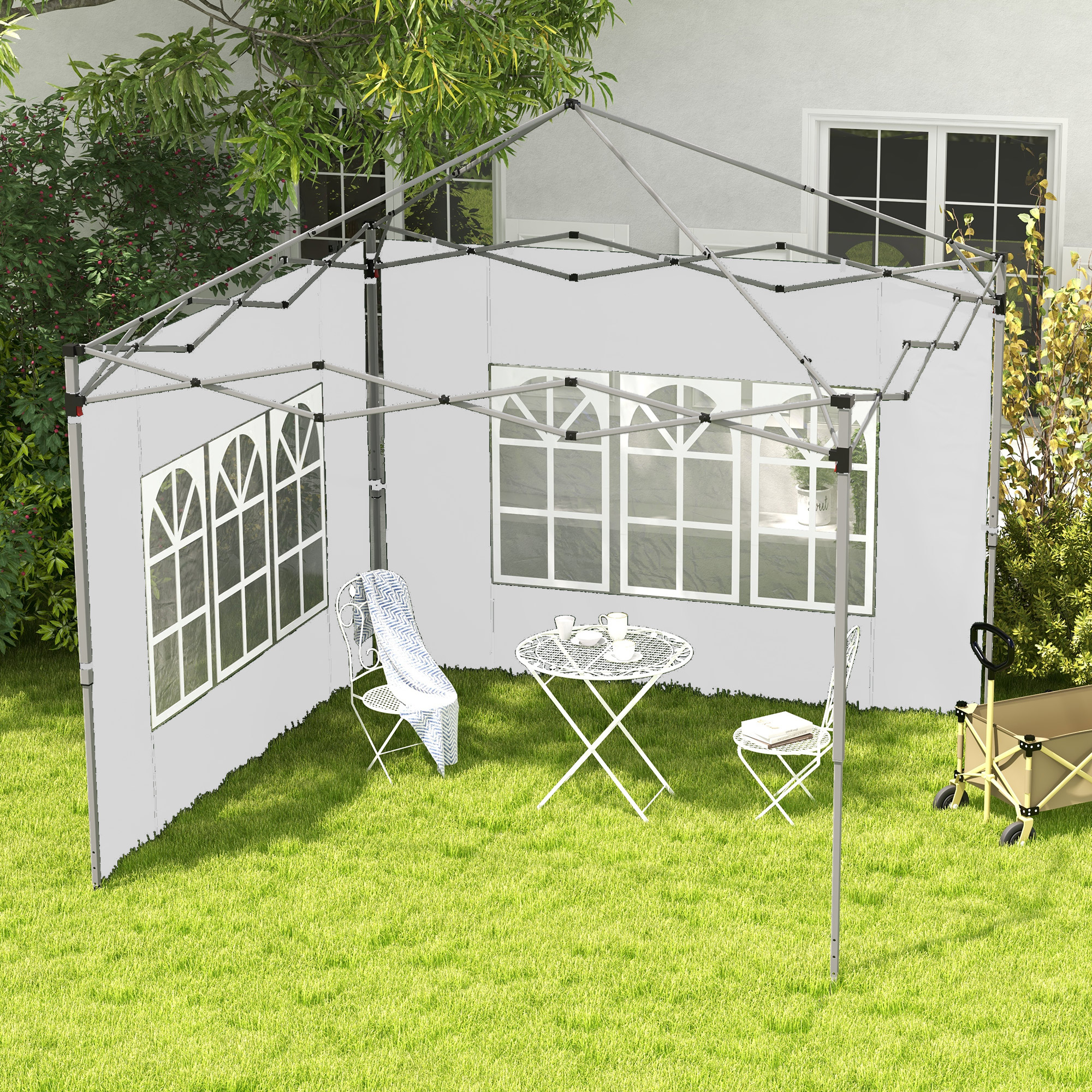 Una carpa blanca con ventanas está en un césped con muebles y un carro.