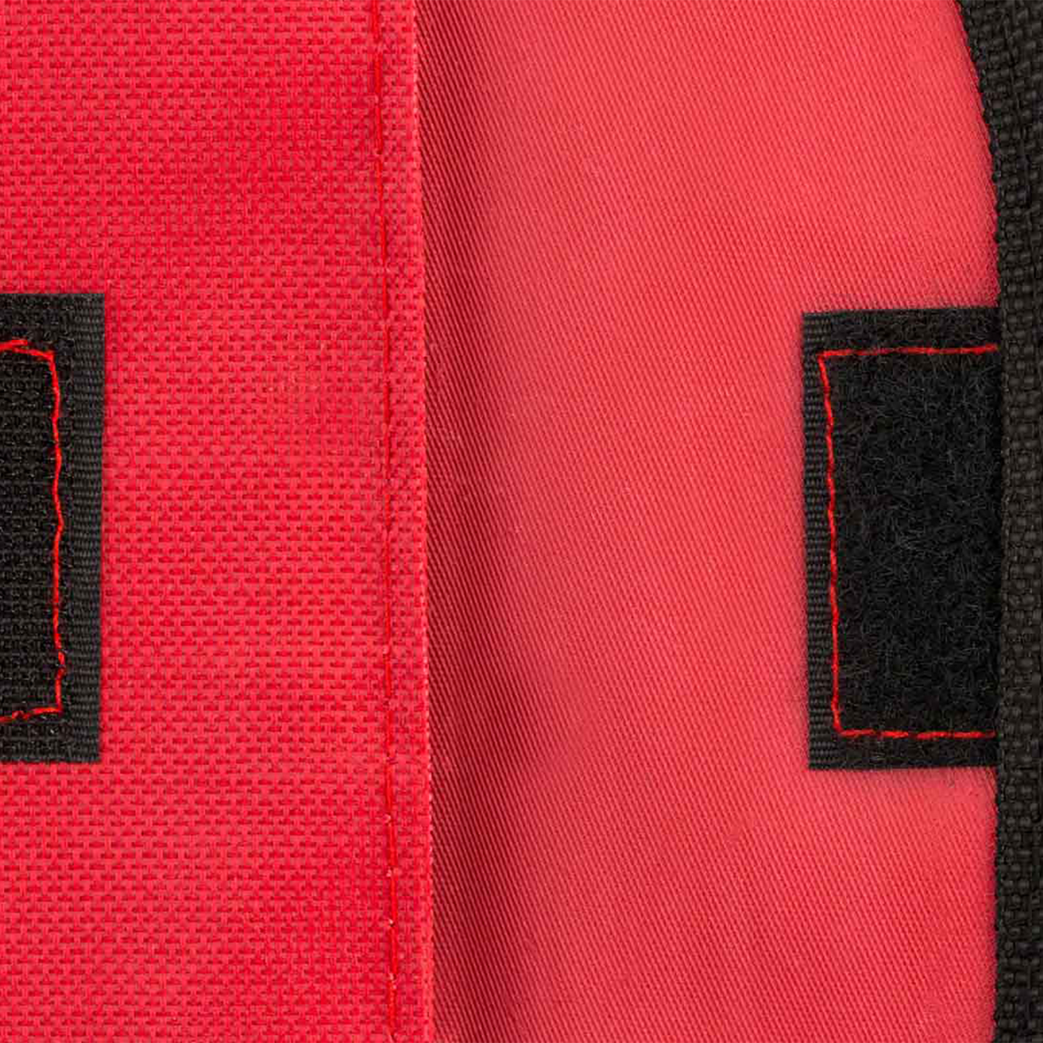 Tessuto rosso con patch in velcro nero, bordati di rosso.