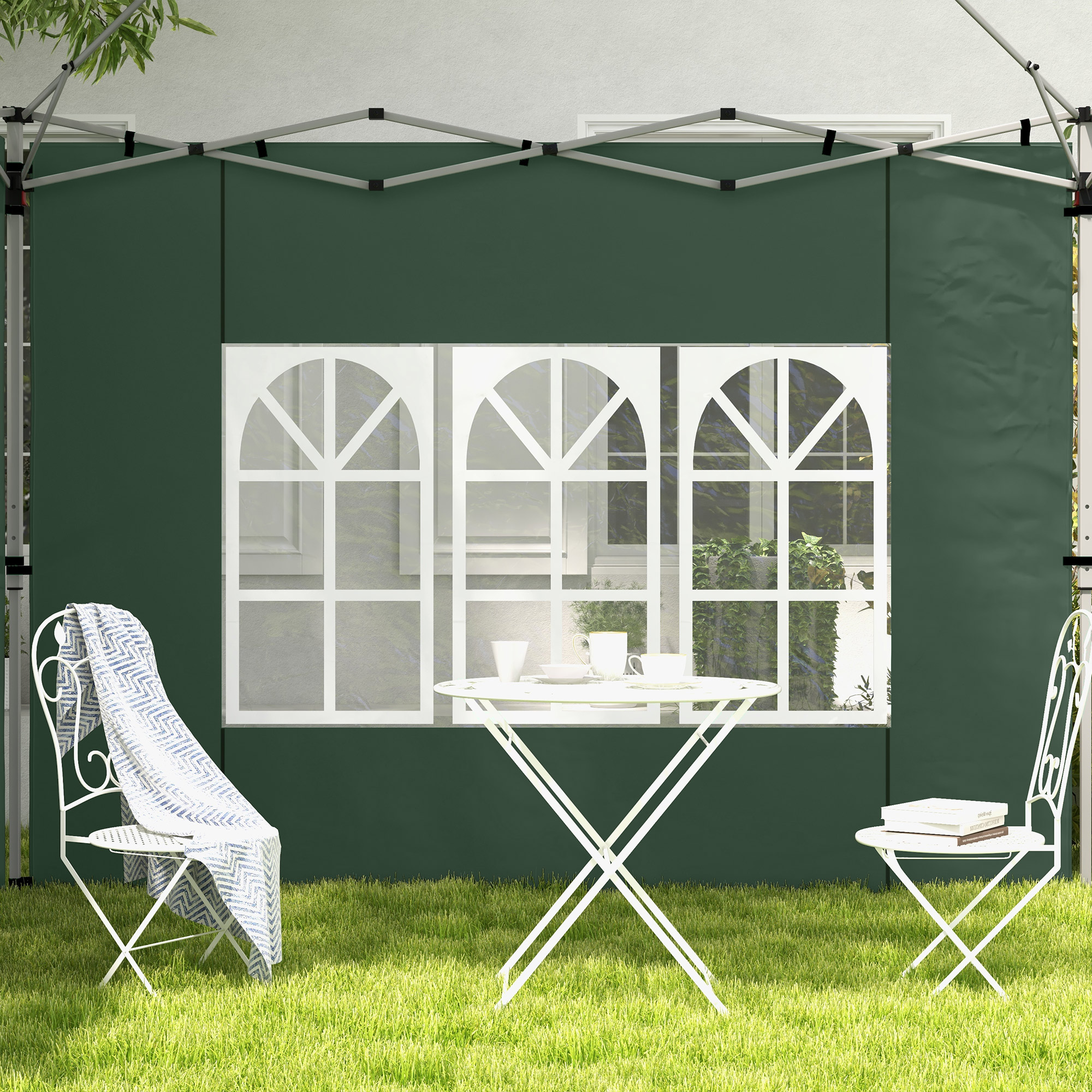 Carpa verde con ventanas, mesa y sillas sobre césped.