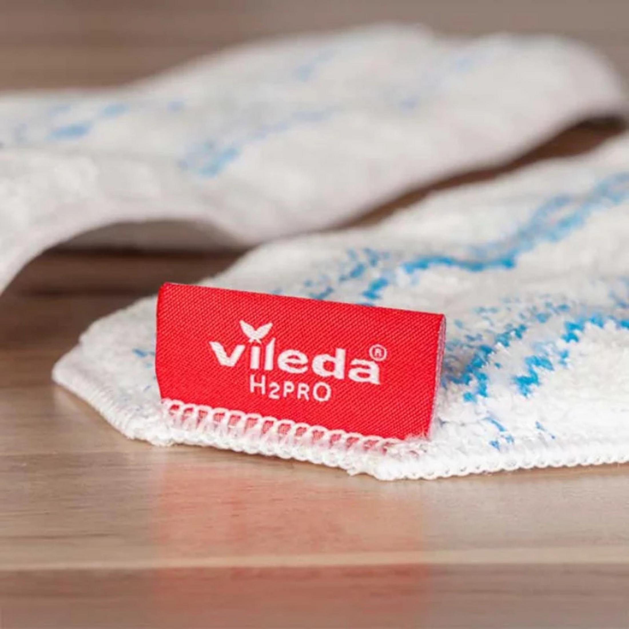 Una etiqueta roja Vileda H2PRO en una mopa blanca con patrones azules.