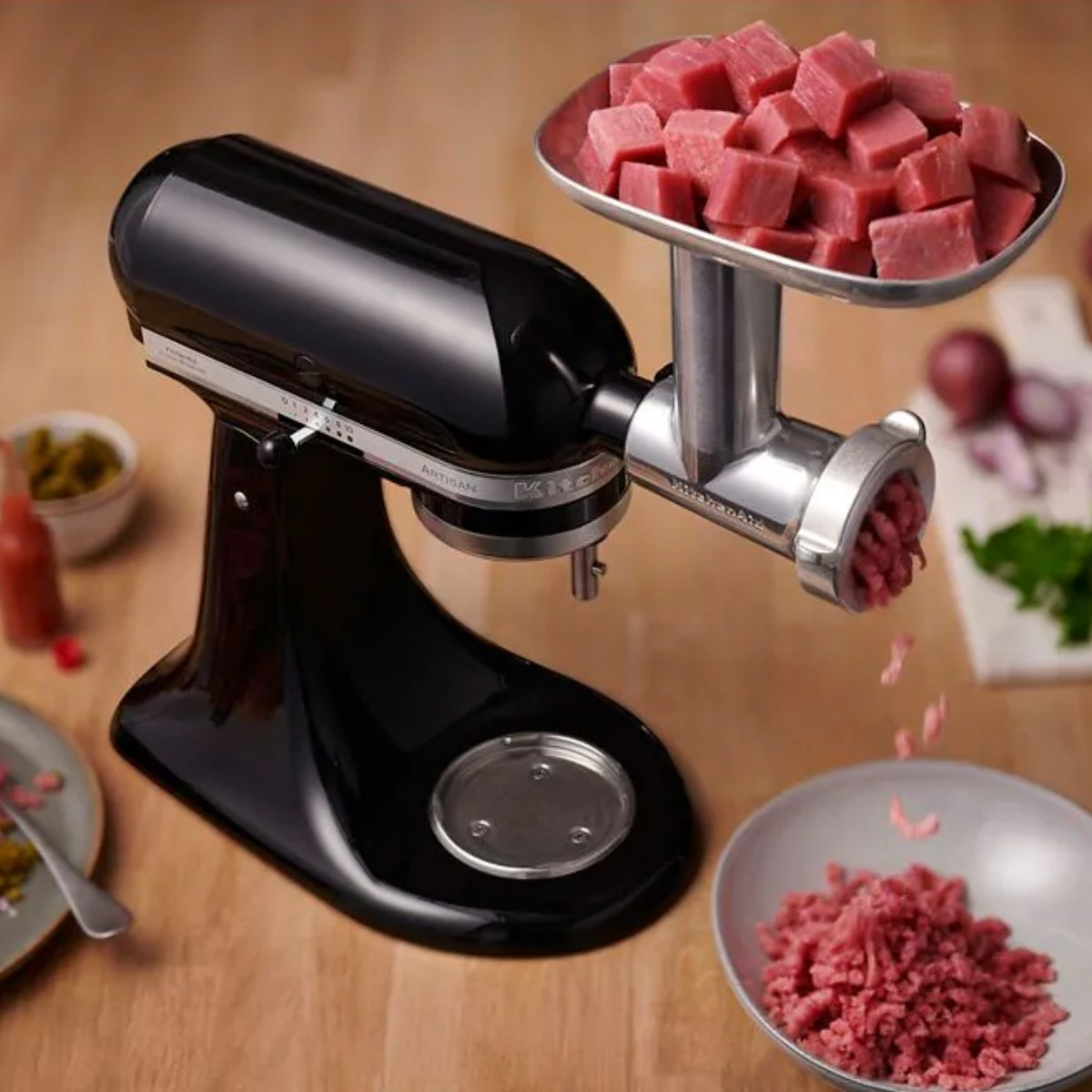 Impastatrice nera con tritacarne, macina carne in una ciotola.