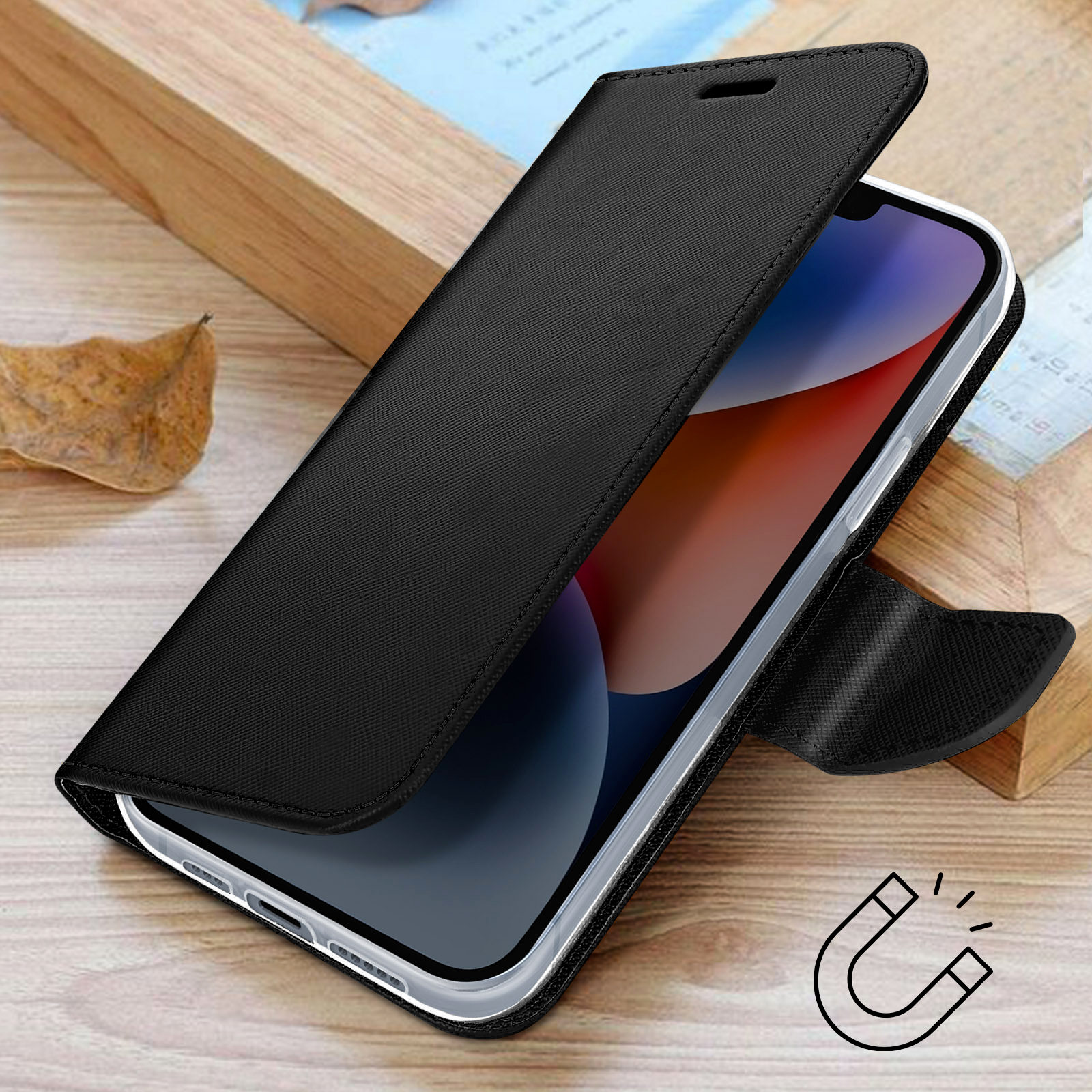 Telefono nero con cover a libro su sfondo di legno, con foglia e icona magnete.