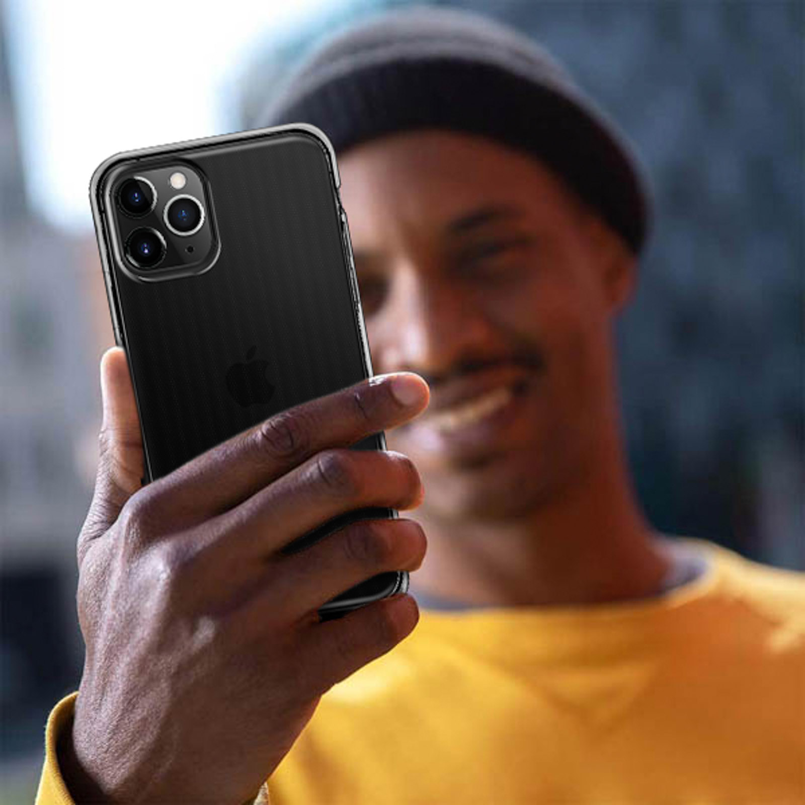 Uomo che tiene un iPhone nero con tre fotocamere e sorride