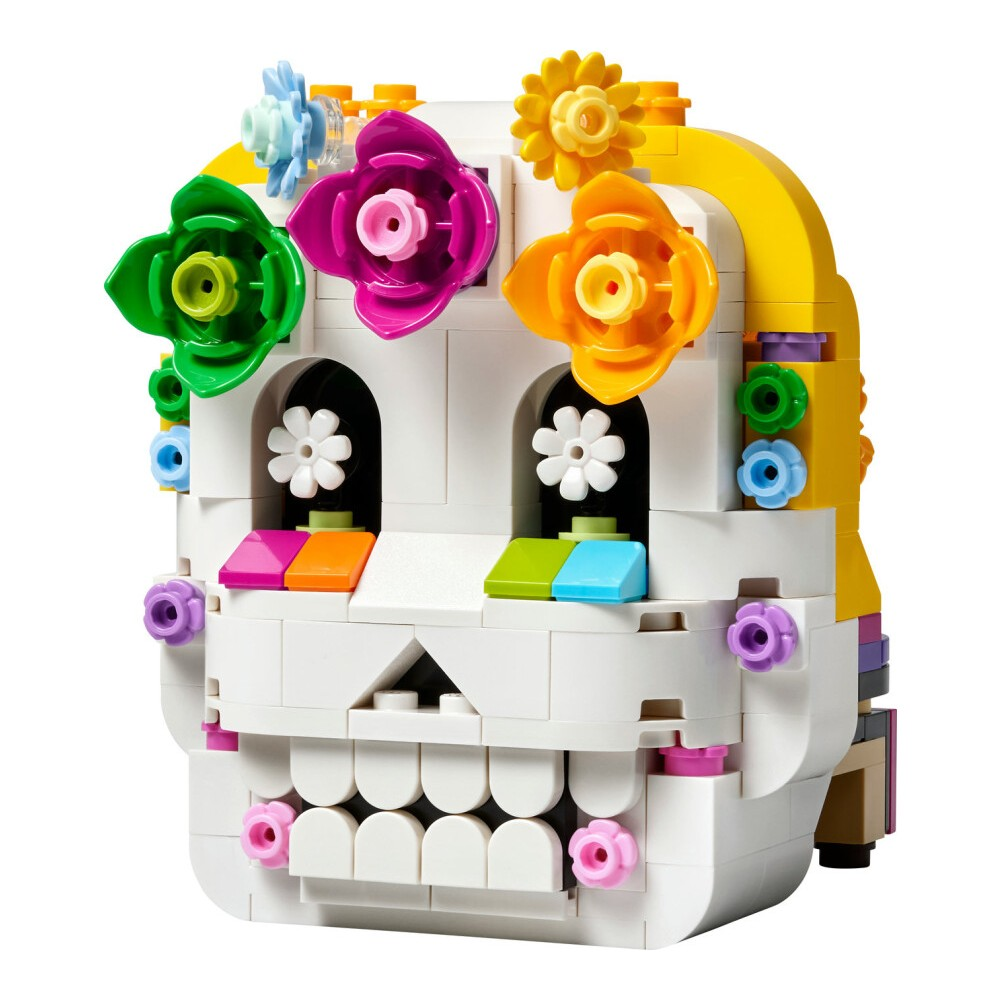 Renkli çiçekler, beyaz dişler ve gözlerle süslenmiş Lego kurukafa.