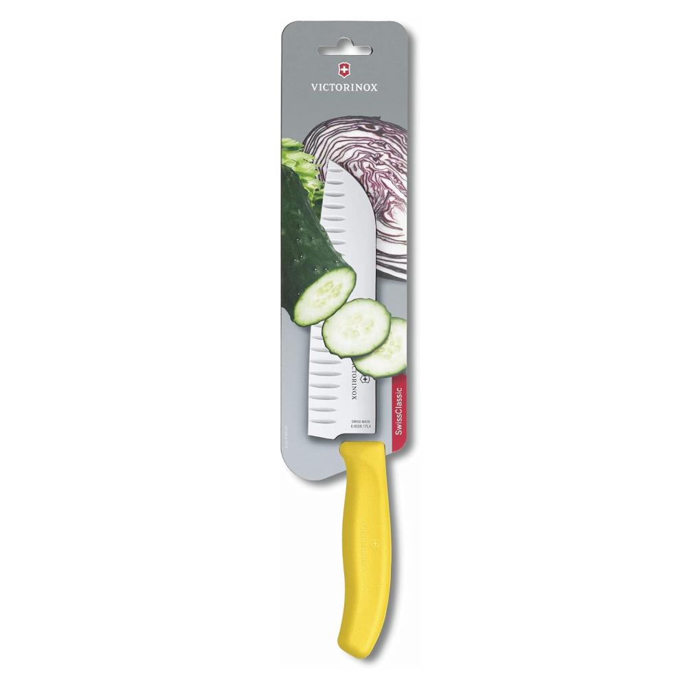 Sarı saplı, tırtıklı Victorinox mutfak bıçağı, salatalık ve kırmızı lahana yanında.