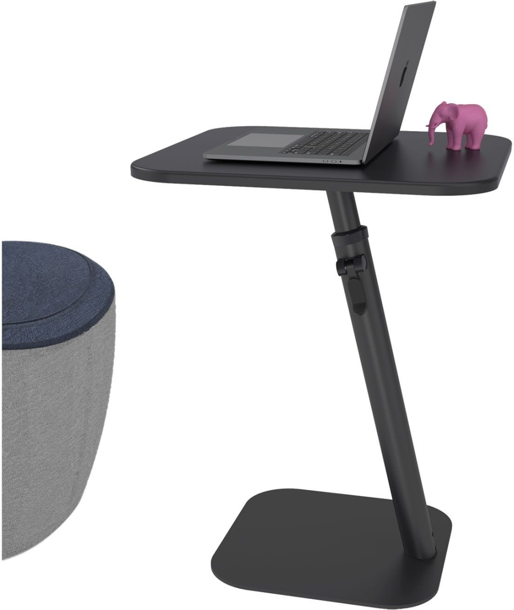 Ein schwarzer Laptop steht auf einem schwarzen, verstellbaren Tisch neben einer rosa Elefantenfigur.