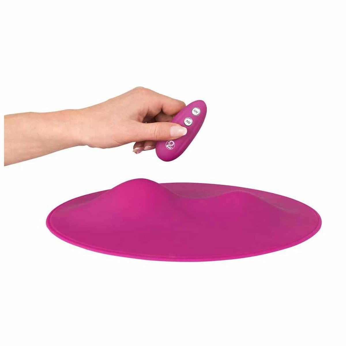 Eine Hand hält eine lila Fernbedienung über einer lila Unterlage.