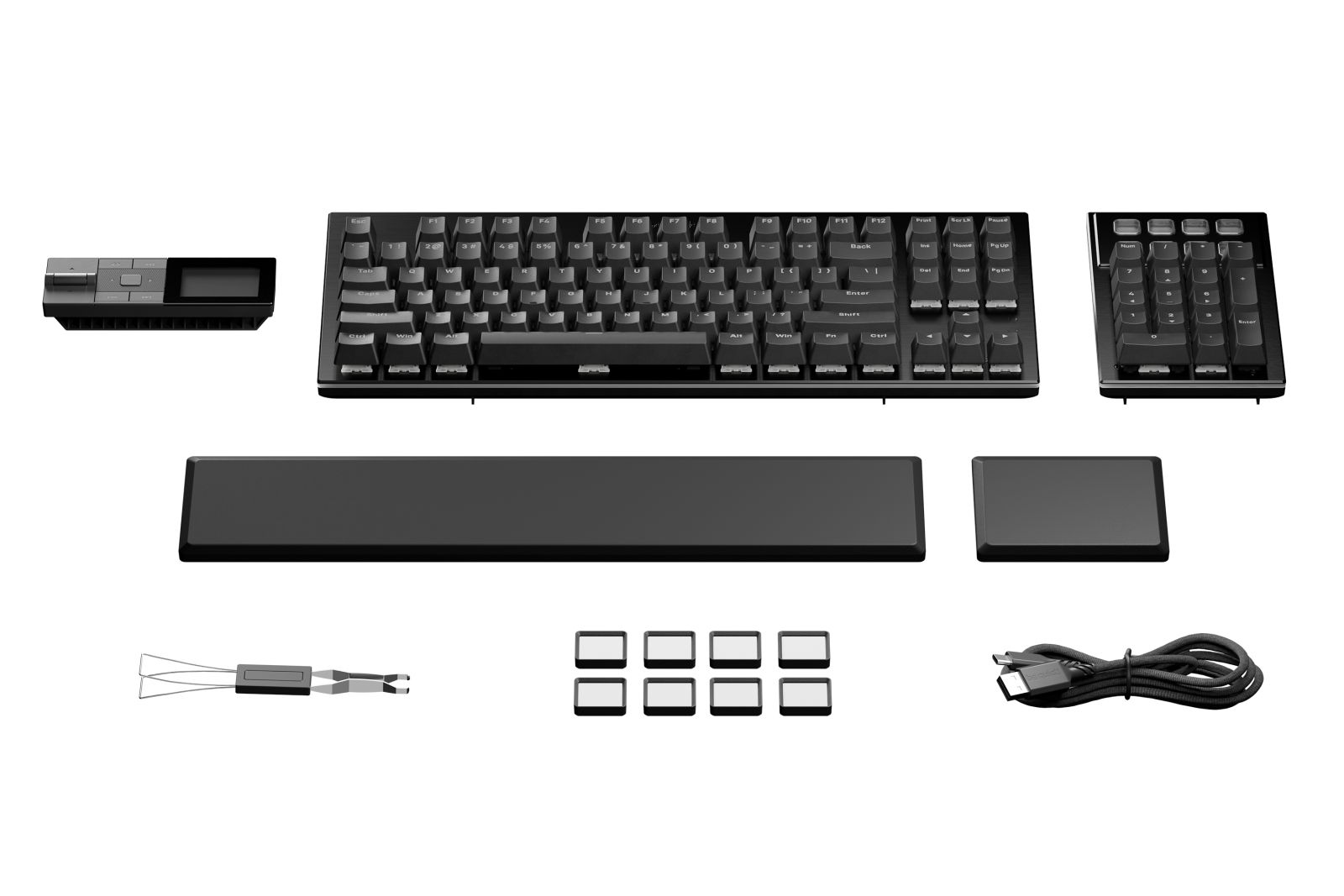 Schwarze Tastatur, Ziffernblock, Handballenauflage und Zubehör auf weißem Grund.