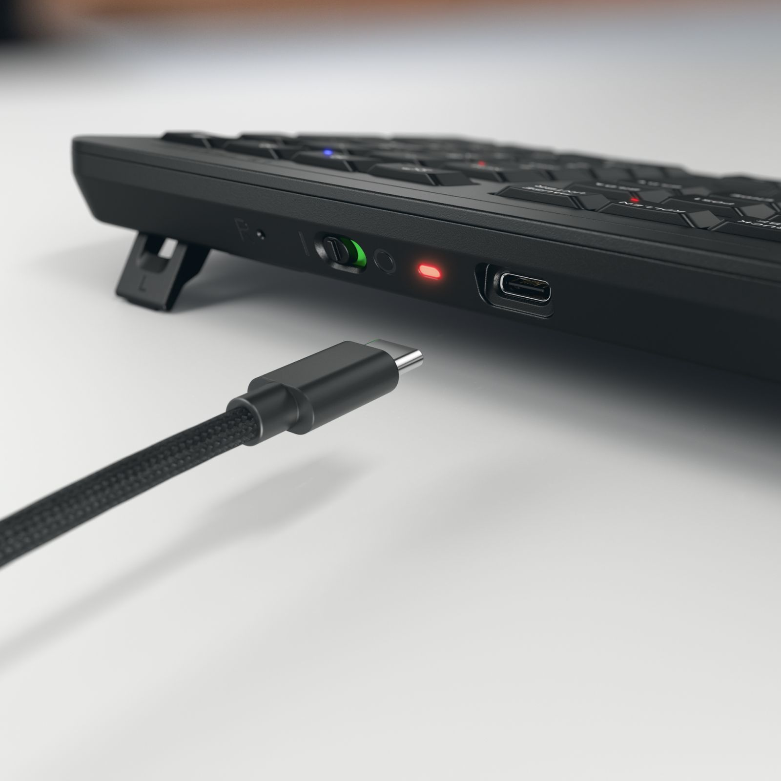 Un cavo USB-C nero è collegato a una tastiera.