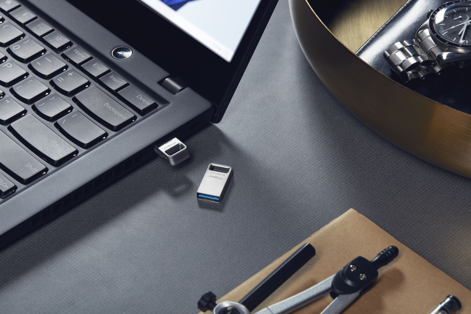 Pendrive jest podłączony do laptopa, a drugi leży obok.