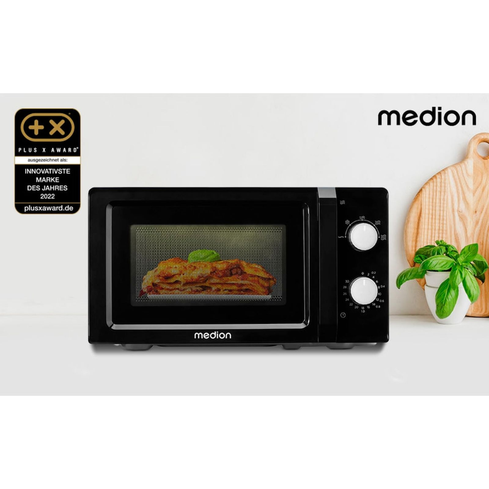 Czarna kuchenka mikrofalowa Medion z lasagne w środku, logo Plus X Award.