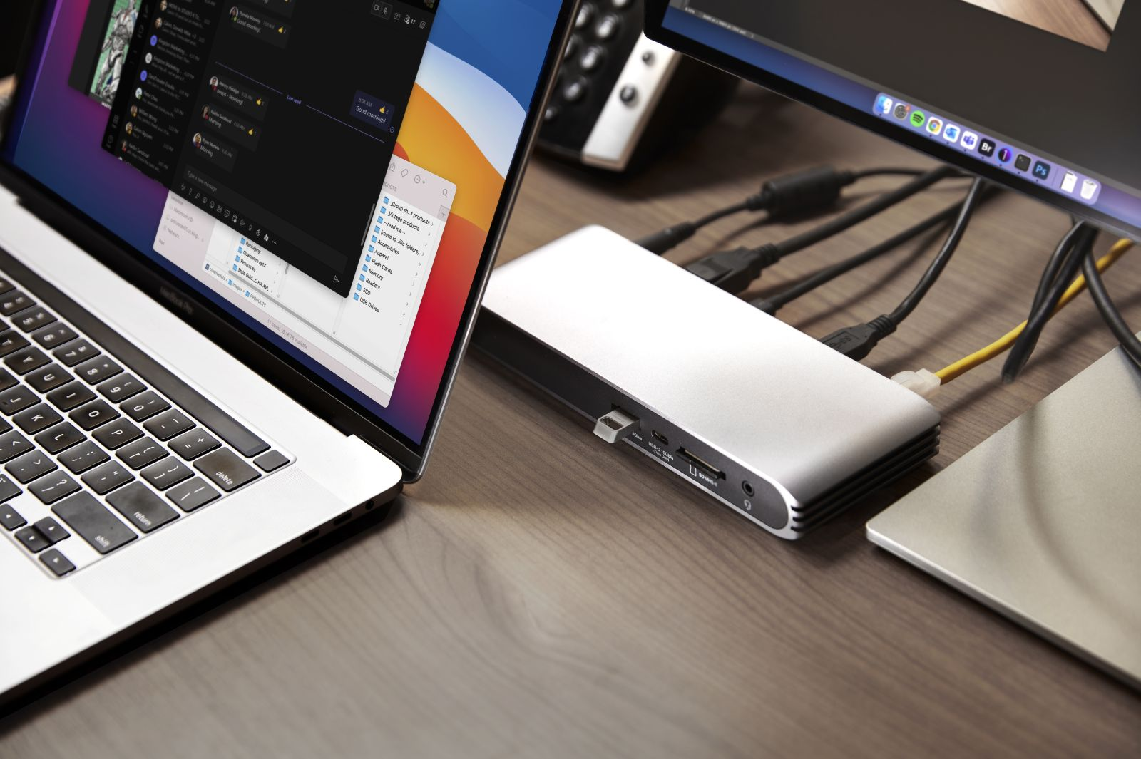 Laptop ze stacją dokującą i monitorem, połączone kablami.