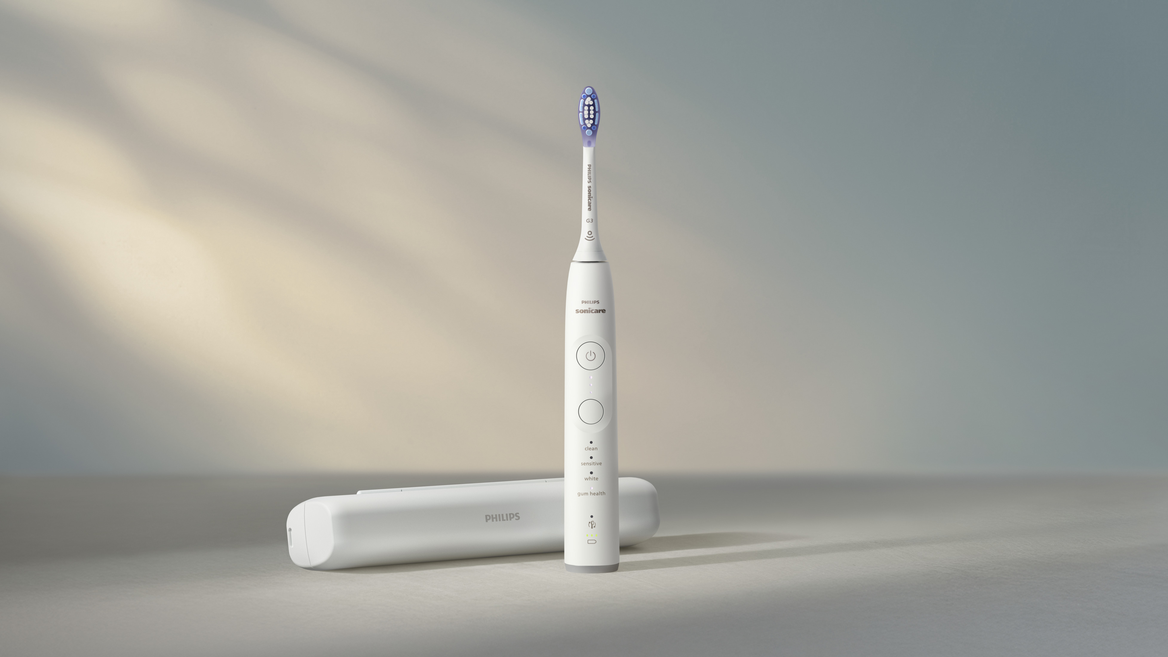 Biała szczoteczka Philips Sonicare z niebieską główką i stacją ładującą.