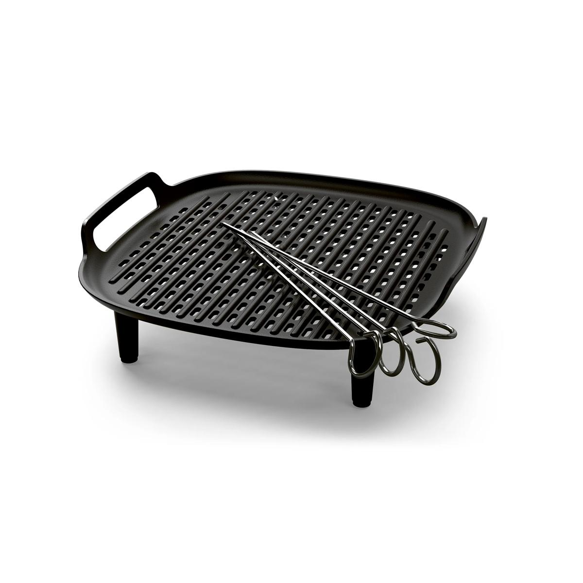 Padella grill nera con due spiedini su sfondo bianco.