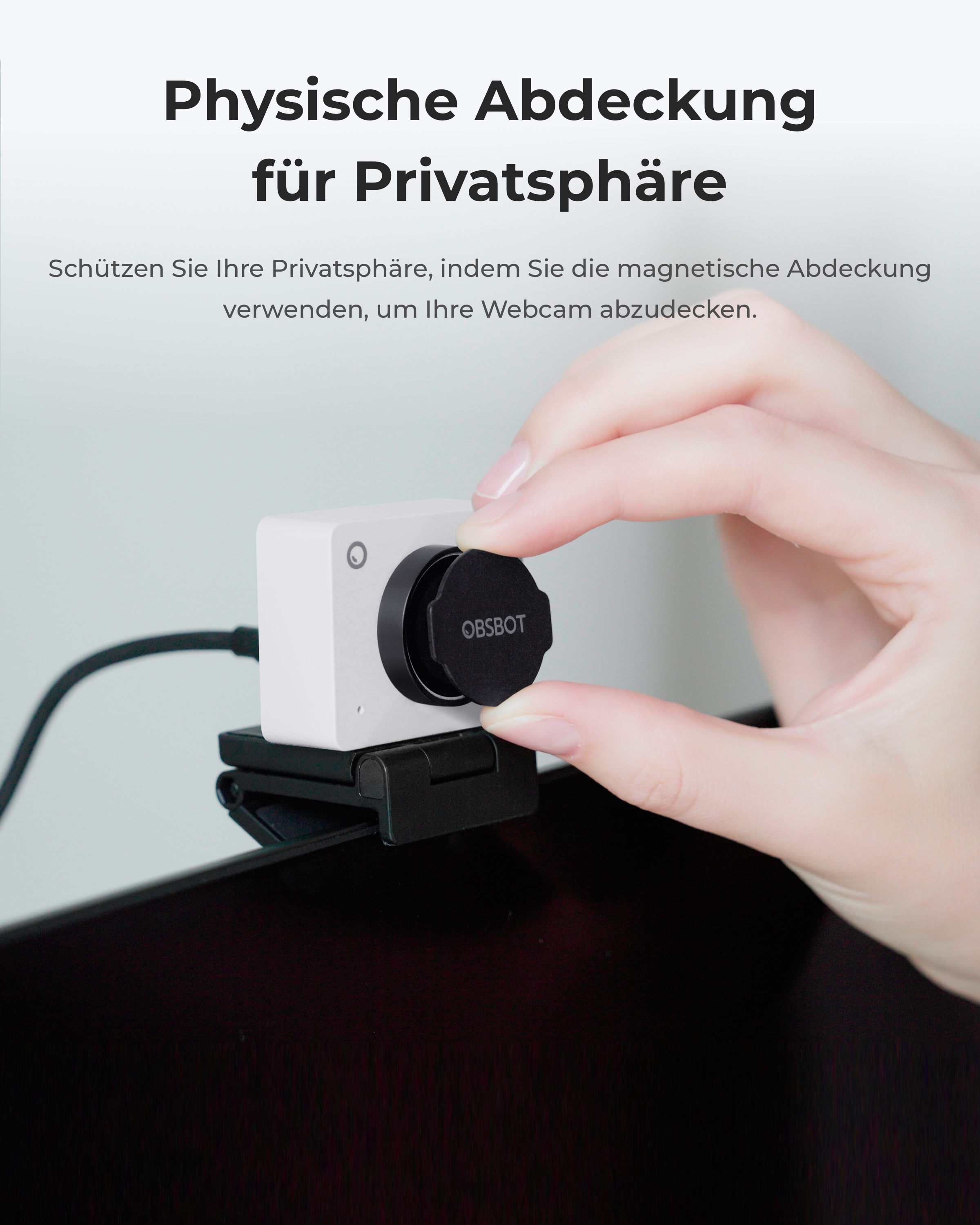 Eine Hand platziert eine schwarze magnetische Abdeckung auf einer OBSBOT-Webcam.