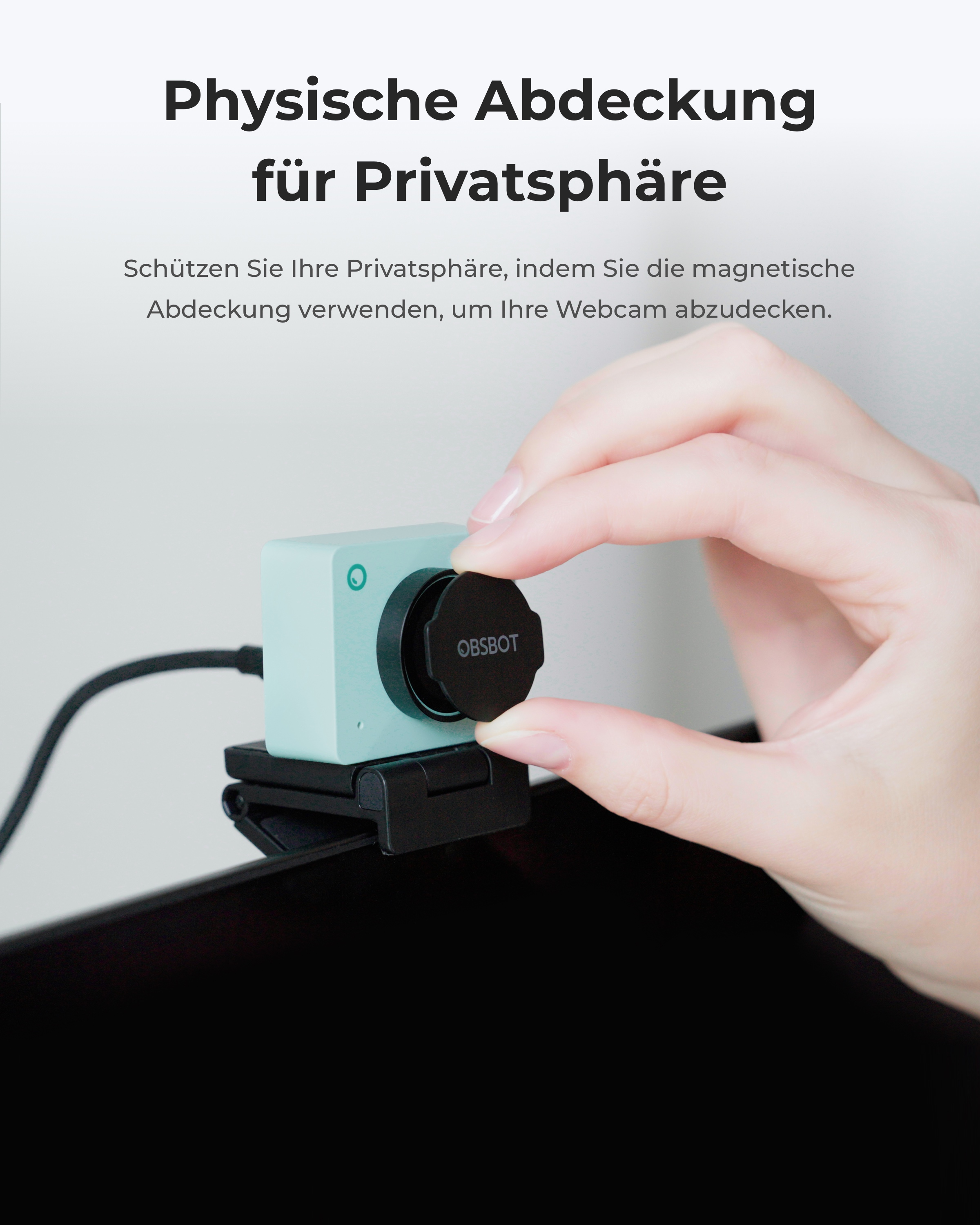 Une main couvre une webcam vert menthe avec un cache noir.