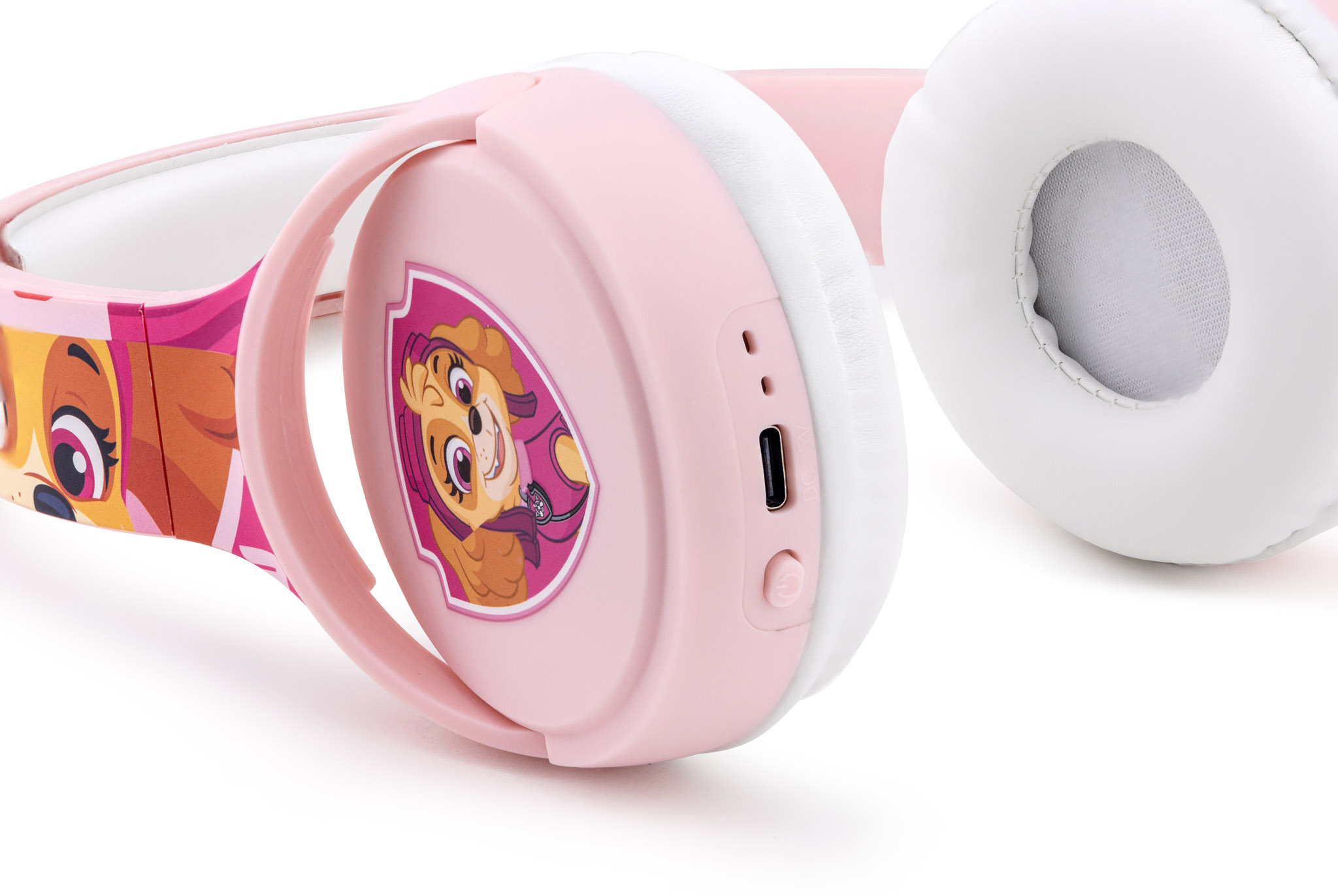 Różowe słuchawki z motywem Psiego Patrolu, białe nauszniki i port ładowania.