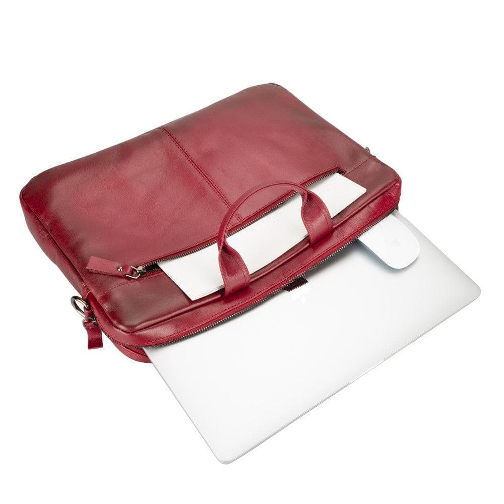 Beyaz arka plan üzerinde laptop ve fareli kırmızı deri çanta.