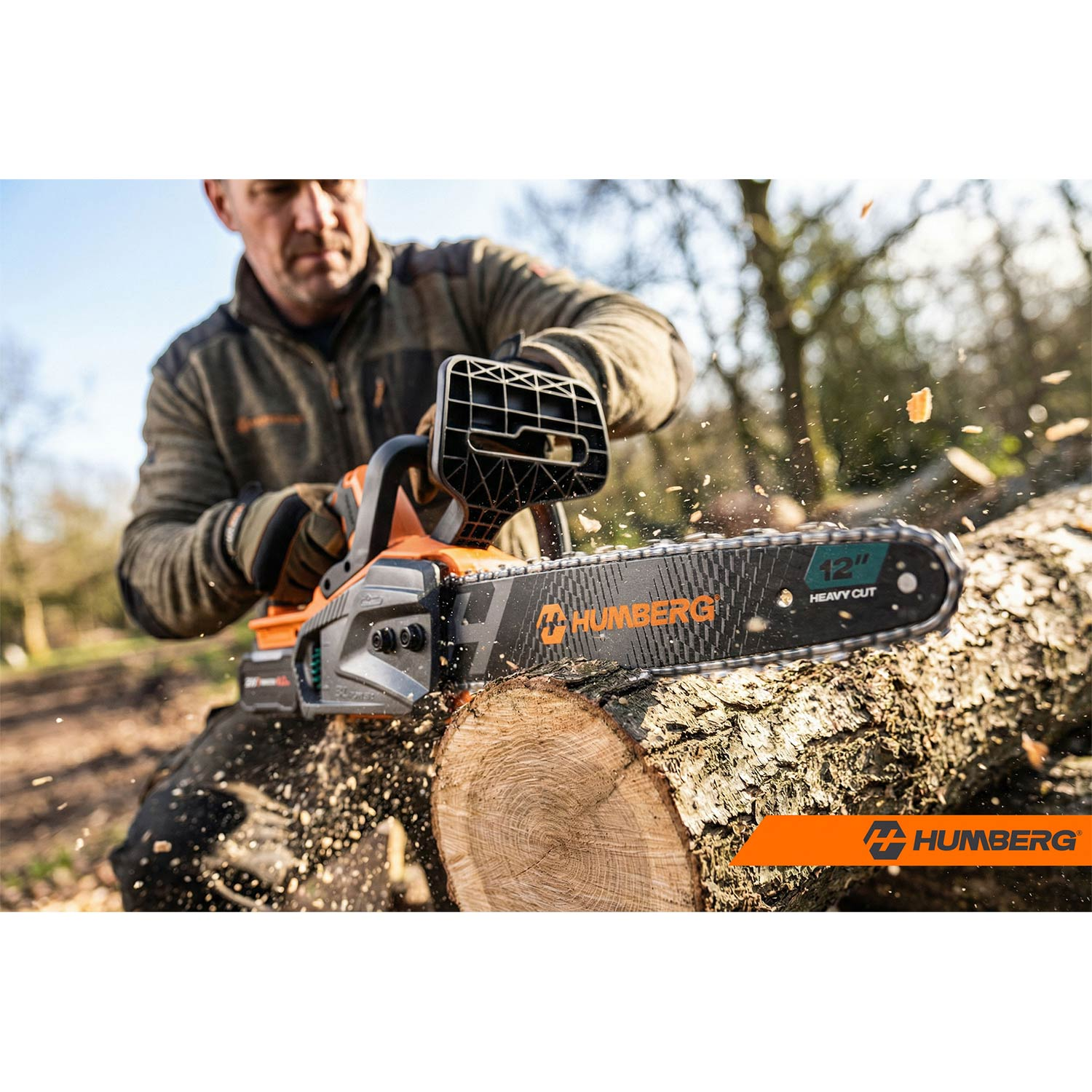 Mężczyzna tnie drewno piłą łańcuchową, lecą wióry.