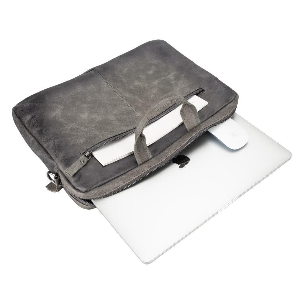 Gri laptop çantası, içinde laptop, fare ve belgeler.