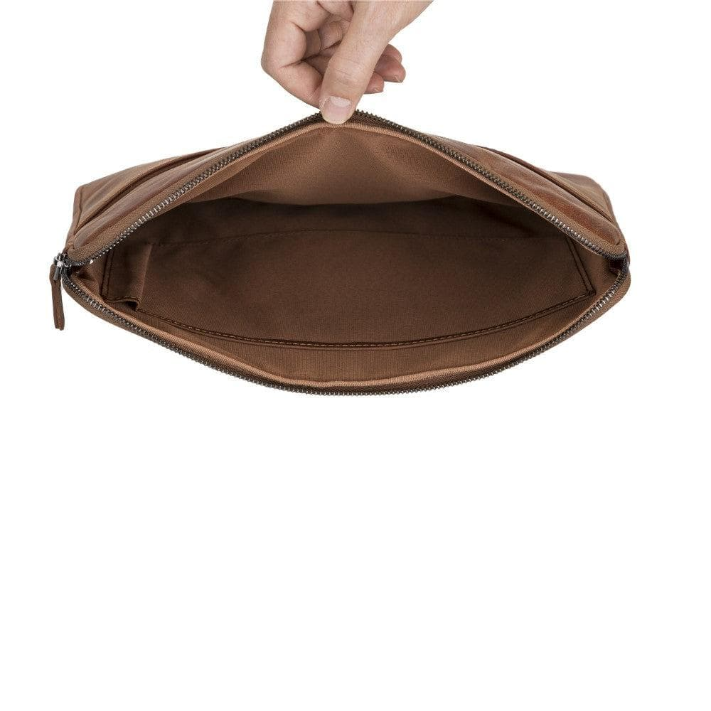 Bir el fermuarlı kahverengi deri clutch çantasını açıyor.