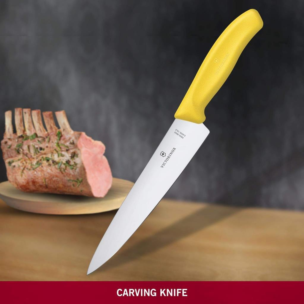 Ahşap kesme tahtası üzerinde çiğ pirzola yanında sarı Victorinox bıçağı.